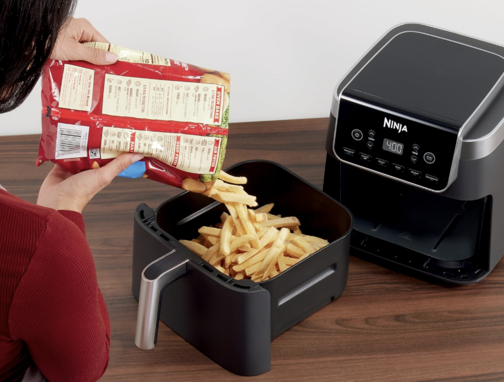 woman pouring fries into air fryer