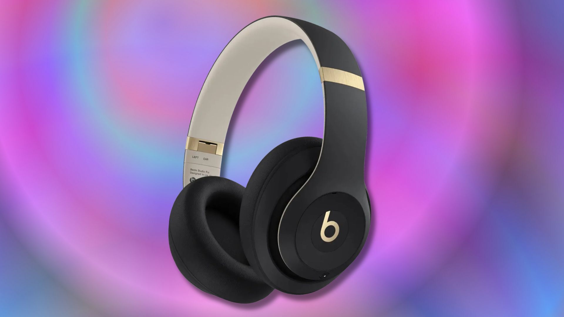 black and gold beats studio pro headphones on a purple and pink background