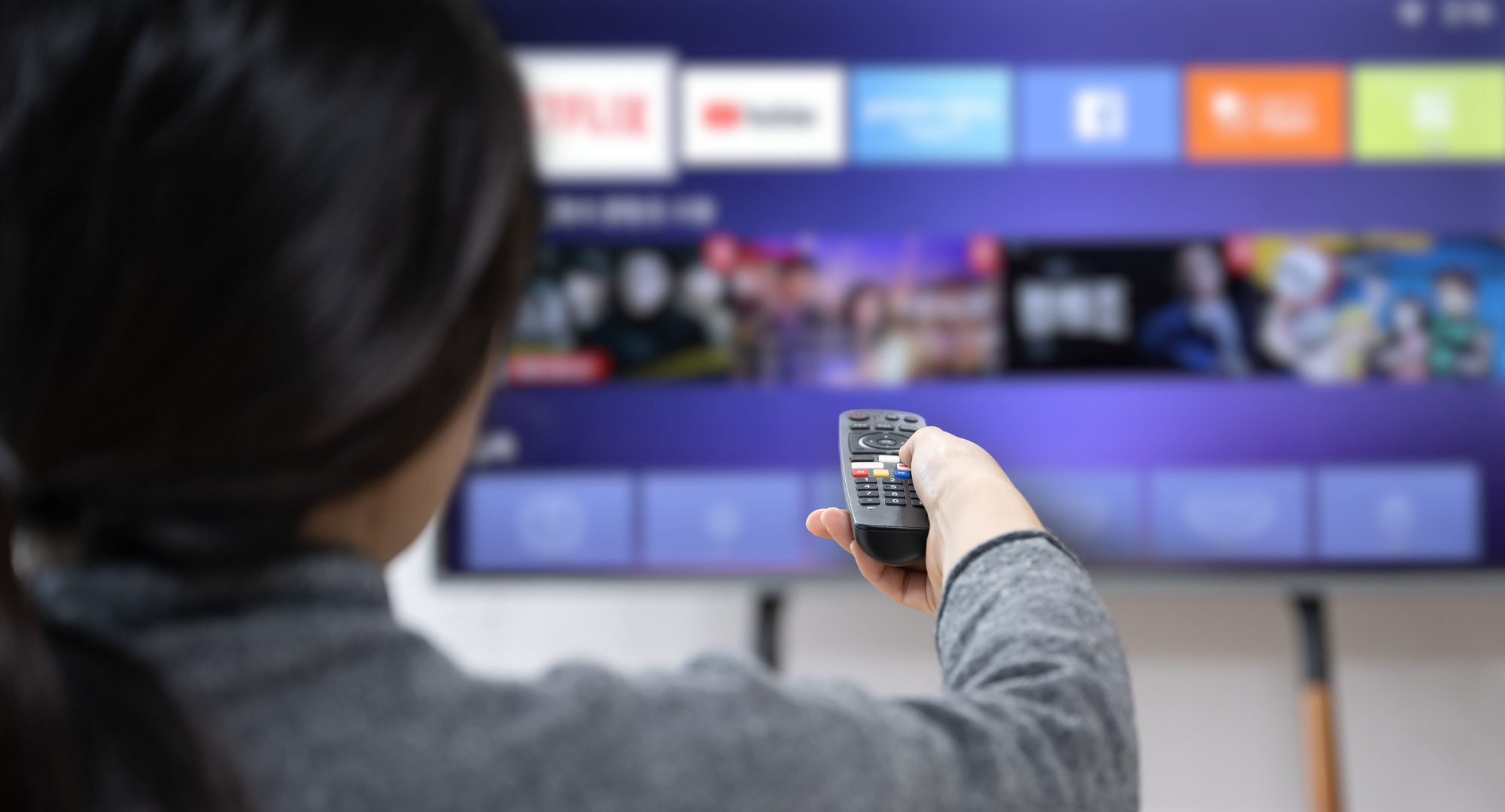 A woman experiences OTT service using a smart TV at home