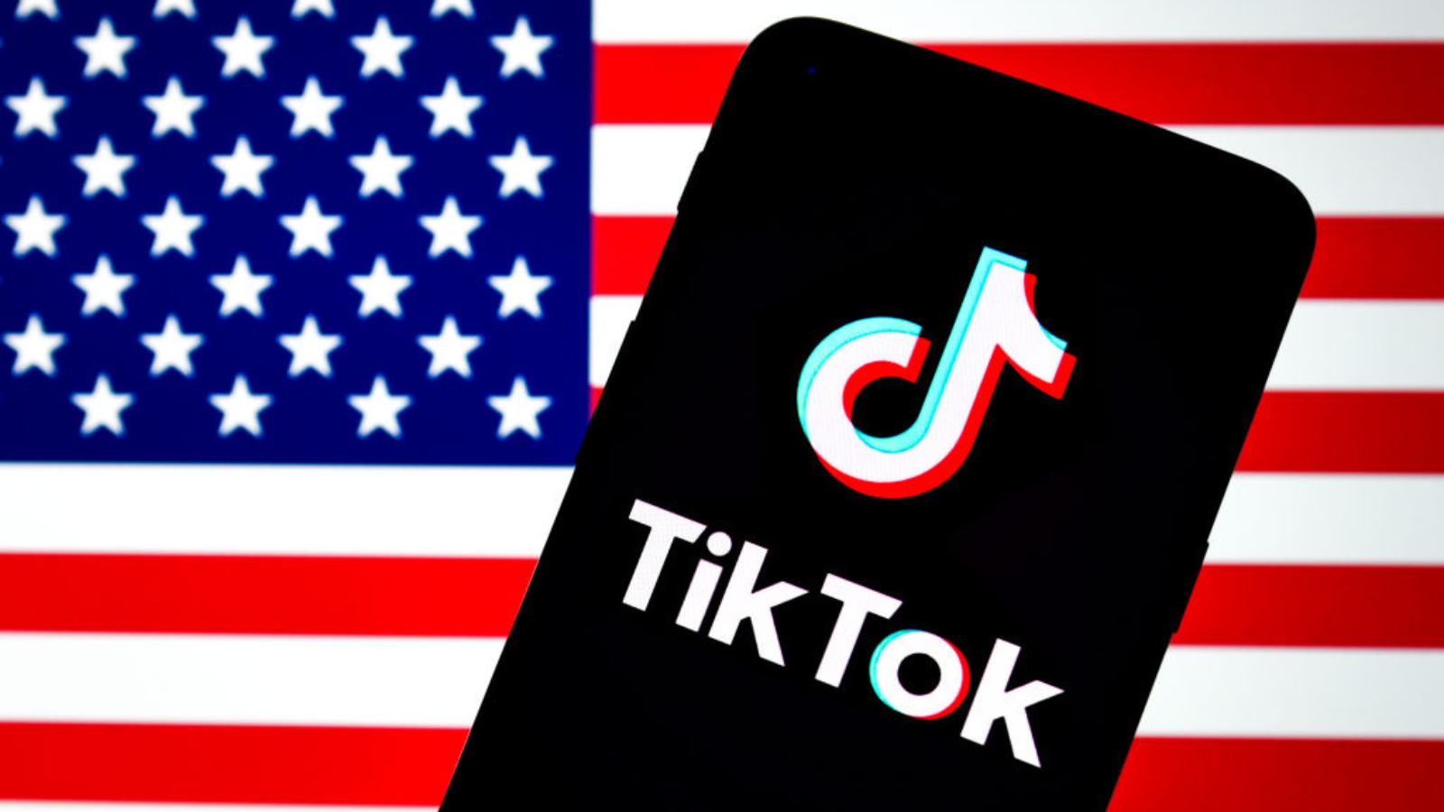 The TikTok logo seen displayed on a smartphone with an American flag in the background.