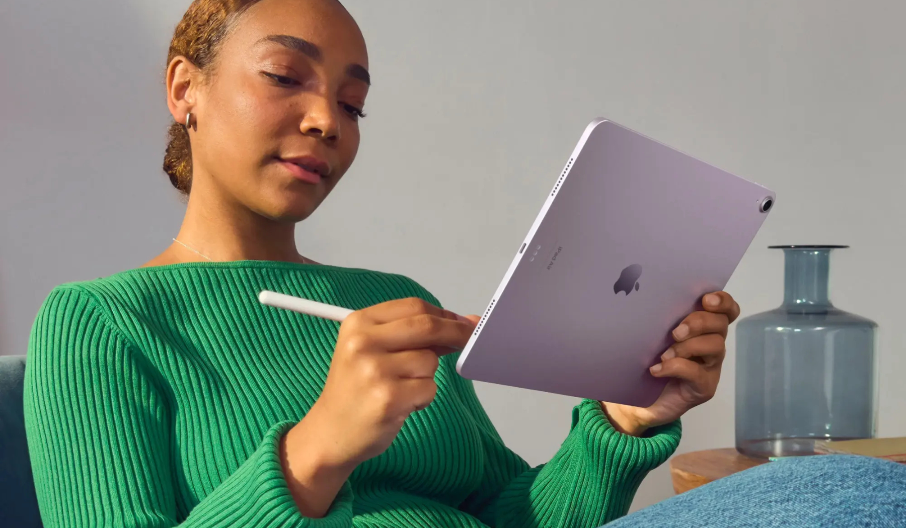 Person writing with Apple Pencil on purple iPad Air