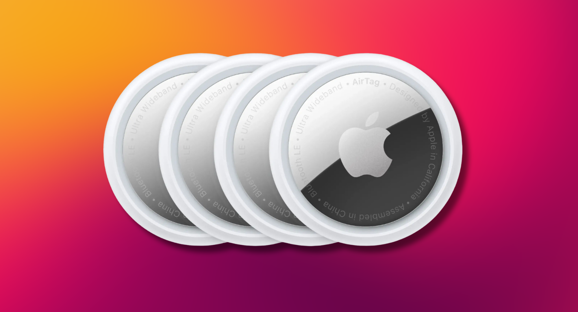 Four Apple AirTags arranged in a row against a colorful gradient background.