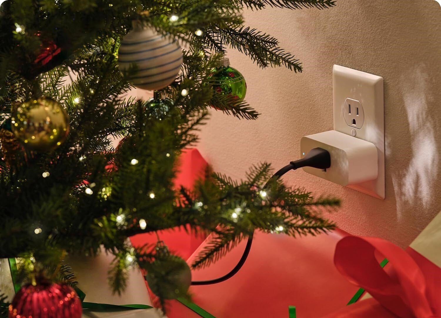 an amazon smart plug sits in an outlet behind a Christmas tree