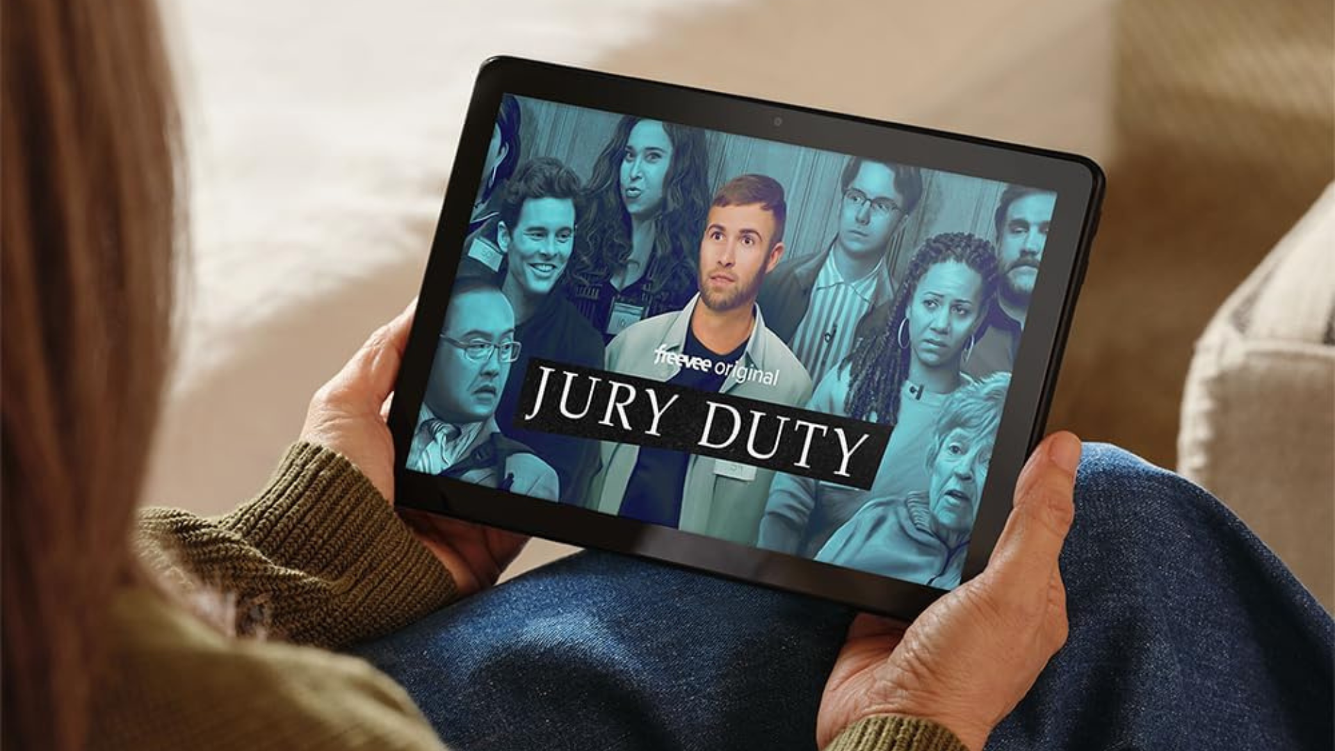 A person holiding an Amazon Fire HD 10 tablet showing the show Jury Duty