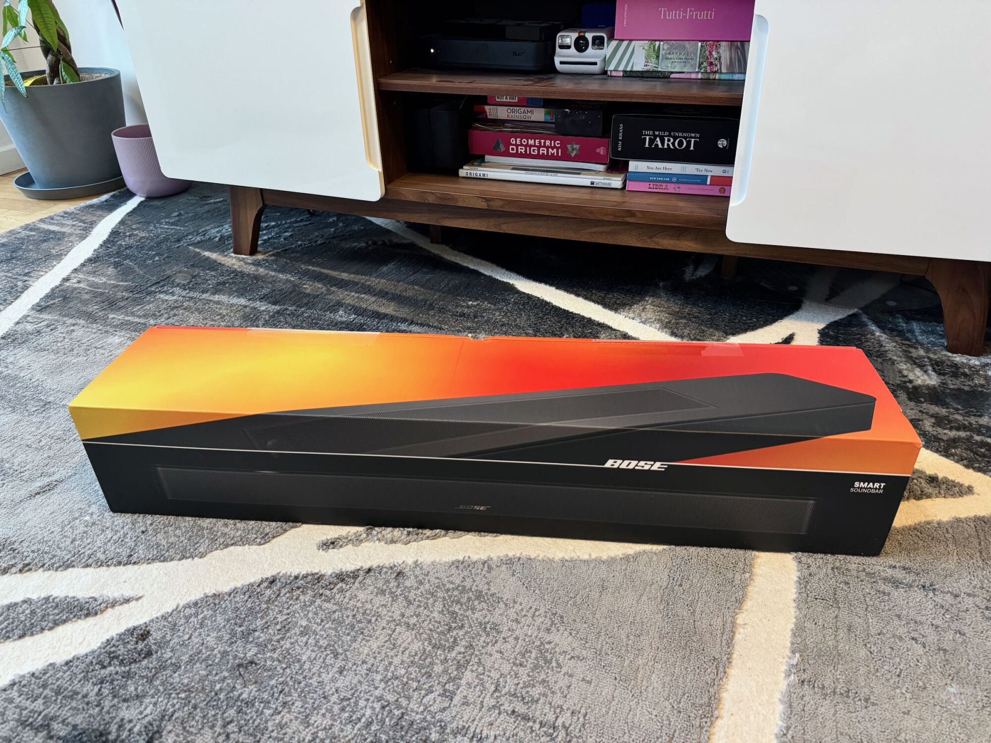 the bose smart soundbar in its box on living room floor