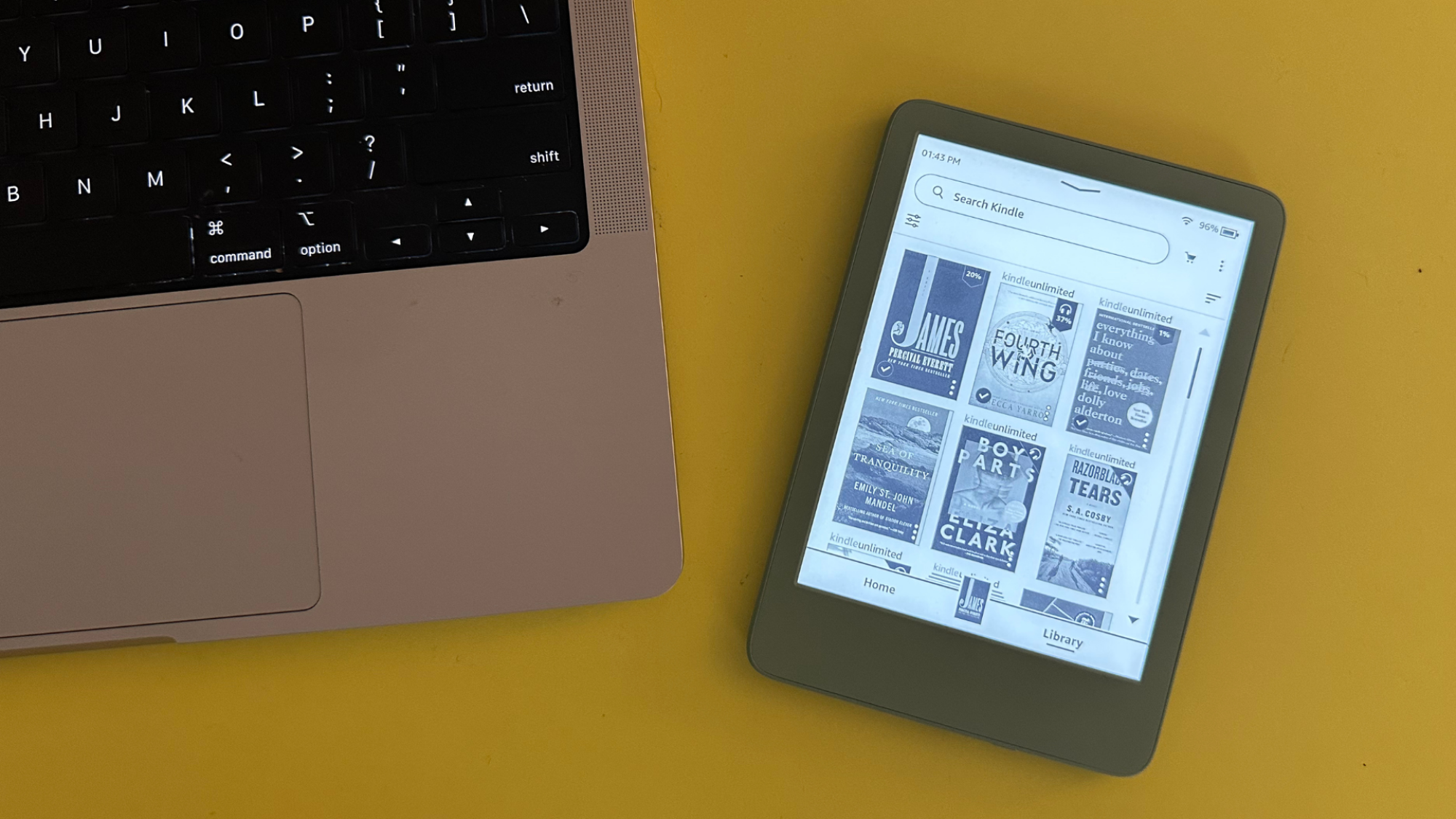 An Amazon Kindle next to a MacBook Pro.