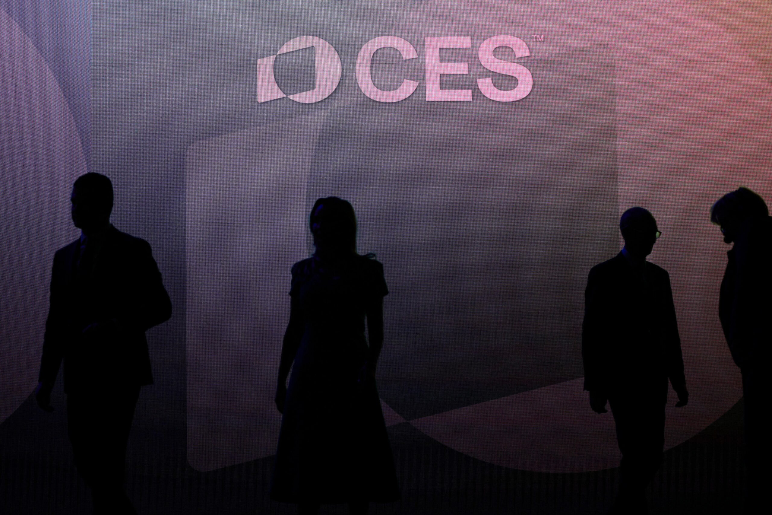 Silhouettes of CES attendees in front of a purple backdrop. 