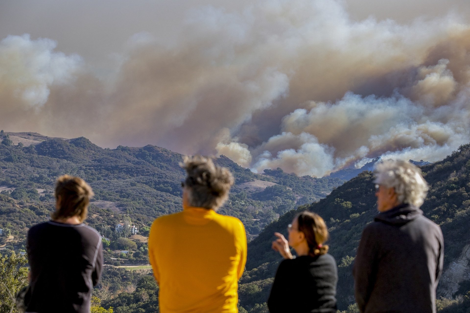 LA-area residents watch fires engulf the hills above Pacific Palisades.