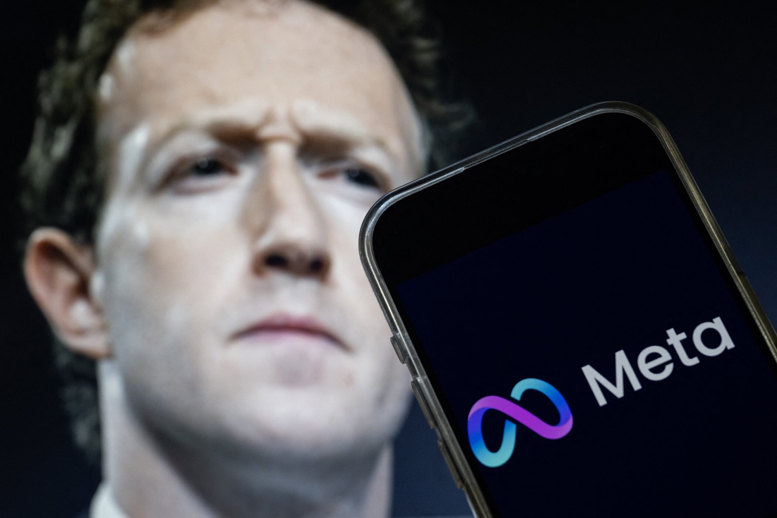 This photo illustration created on January 7, 2025, in Washington, DC, shows an image of Mark Zuckerberg, CEO of Meta, and an image of the Meta logo. Social media giant Meta on January 7, 2025, slashed its content moderation policies, including ending its US fact-checking program, in a major shift that conforms with the priorities of incoming president Donald Trump. 