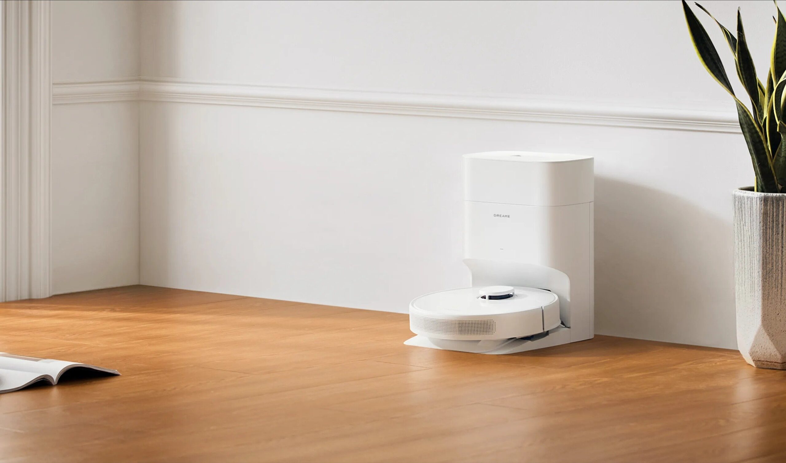 a Dreame D10 Plus Gen 2 robot vacuum and mop sits on its charging and emptying base against a white wall in a clean home