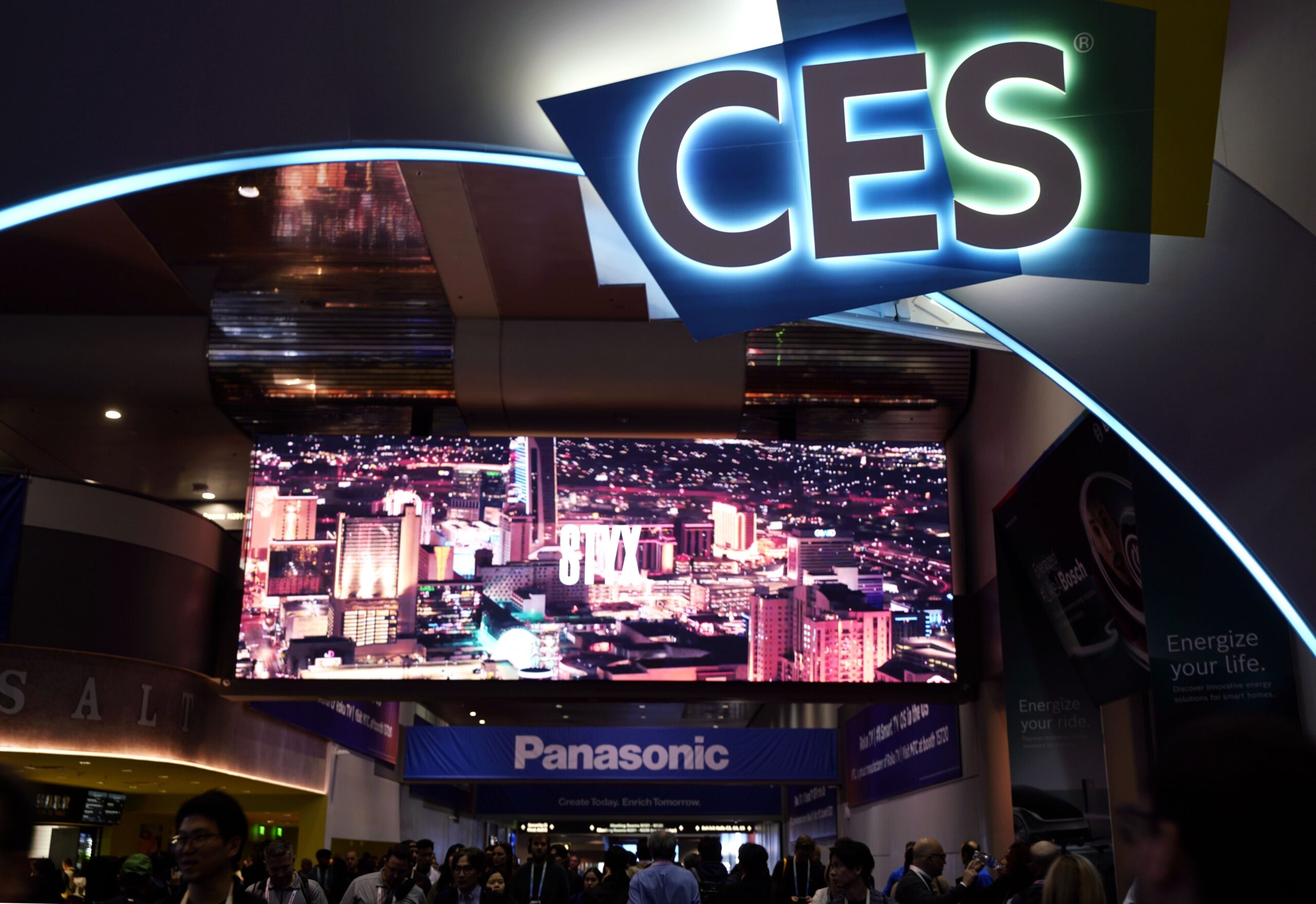 People walking on a conference center below a CES sign.