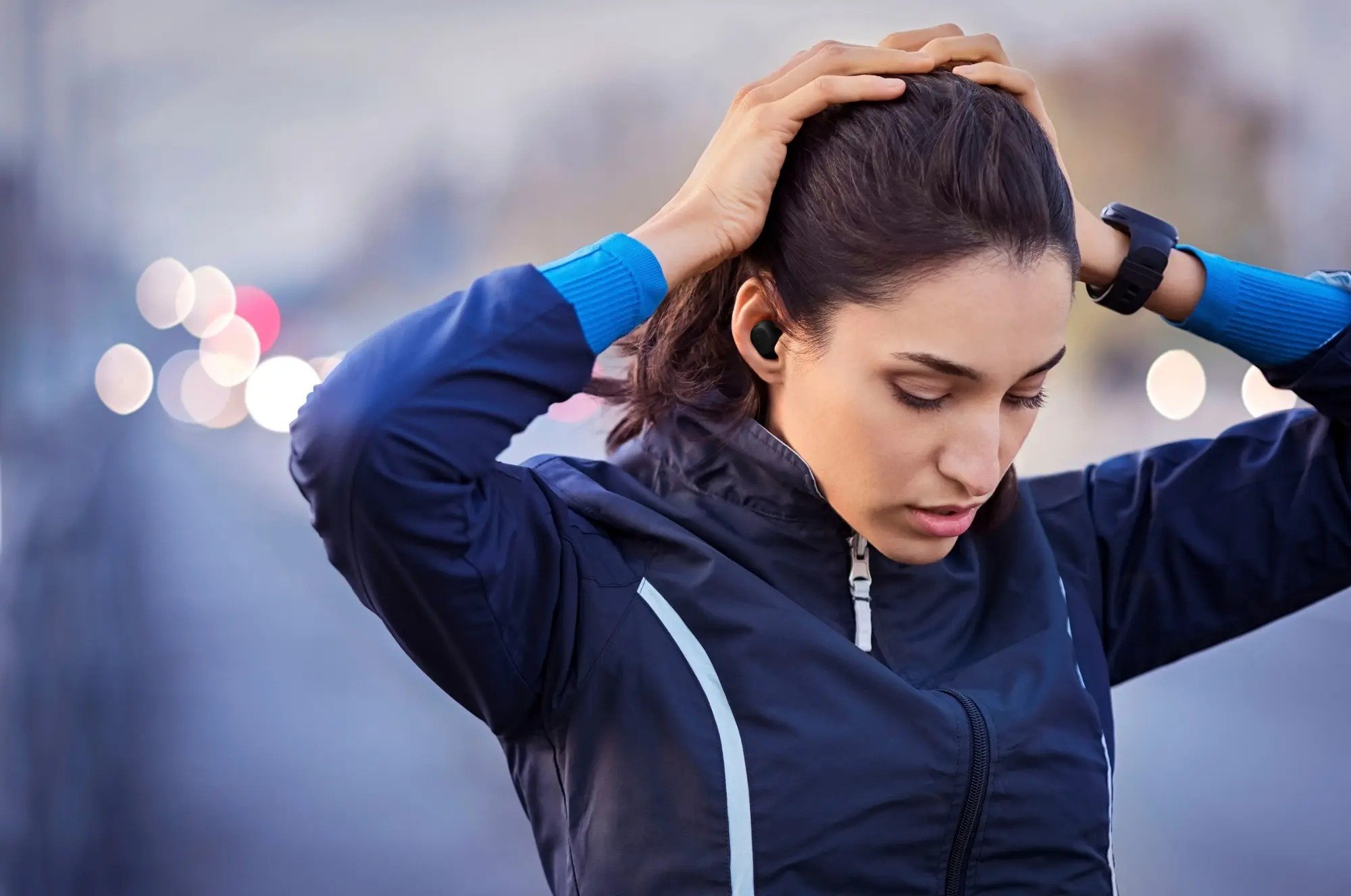 woman in exercise clothes with hands on head wearing jabra elite 8 active gen 2 earbuds