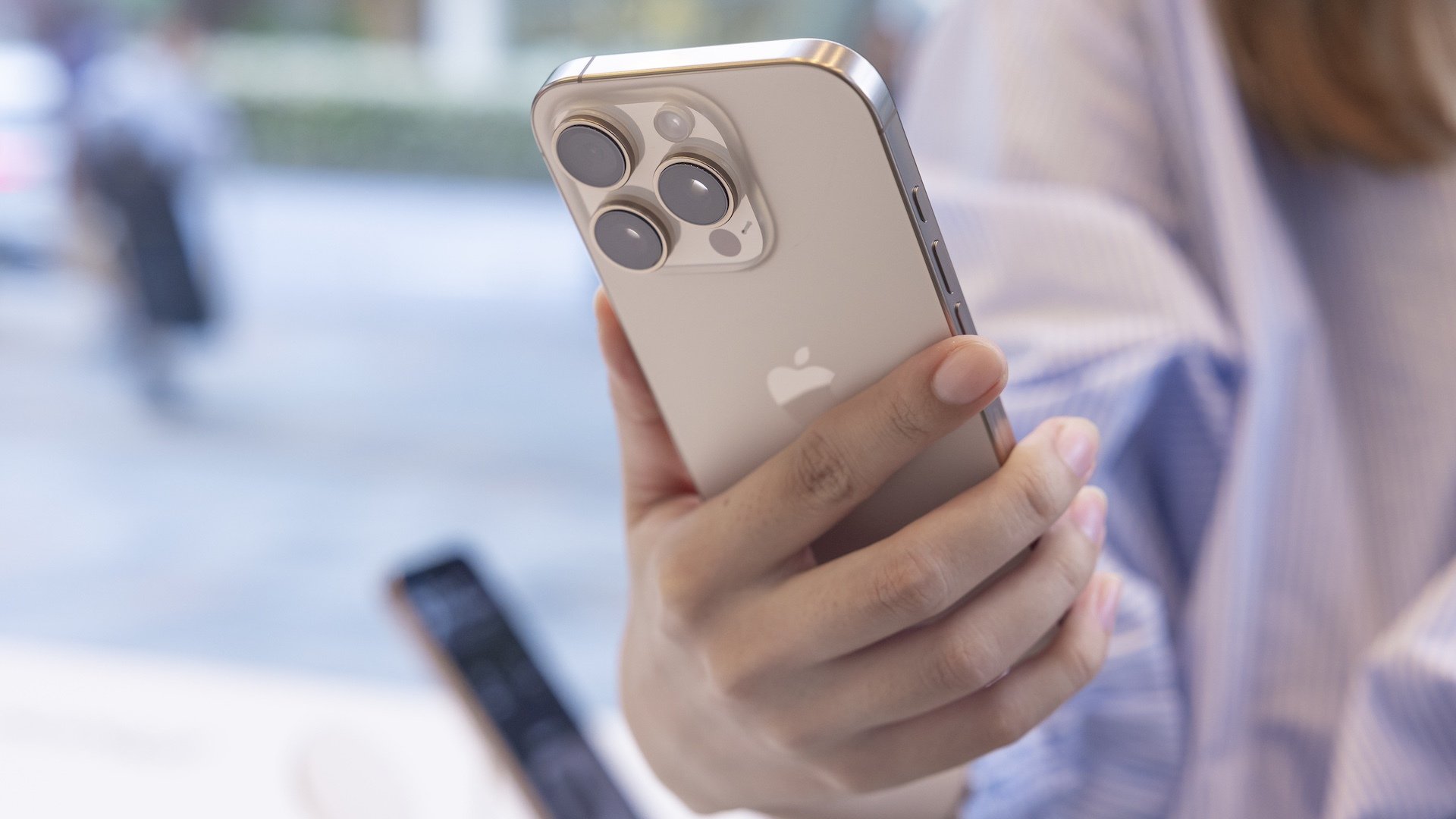 A customer holds the new Apple iPhone 16 Pro in her hand.