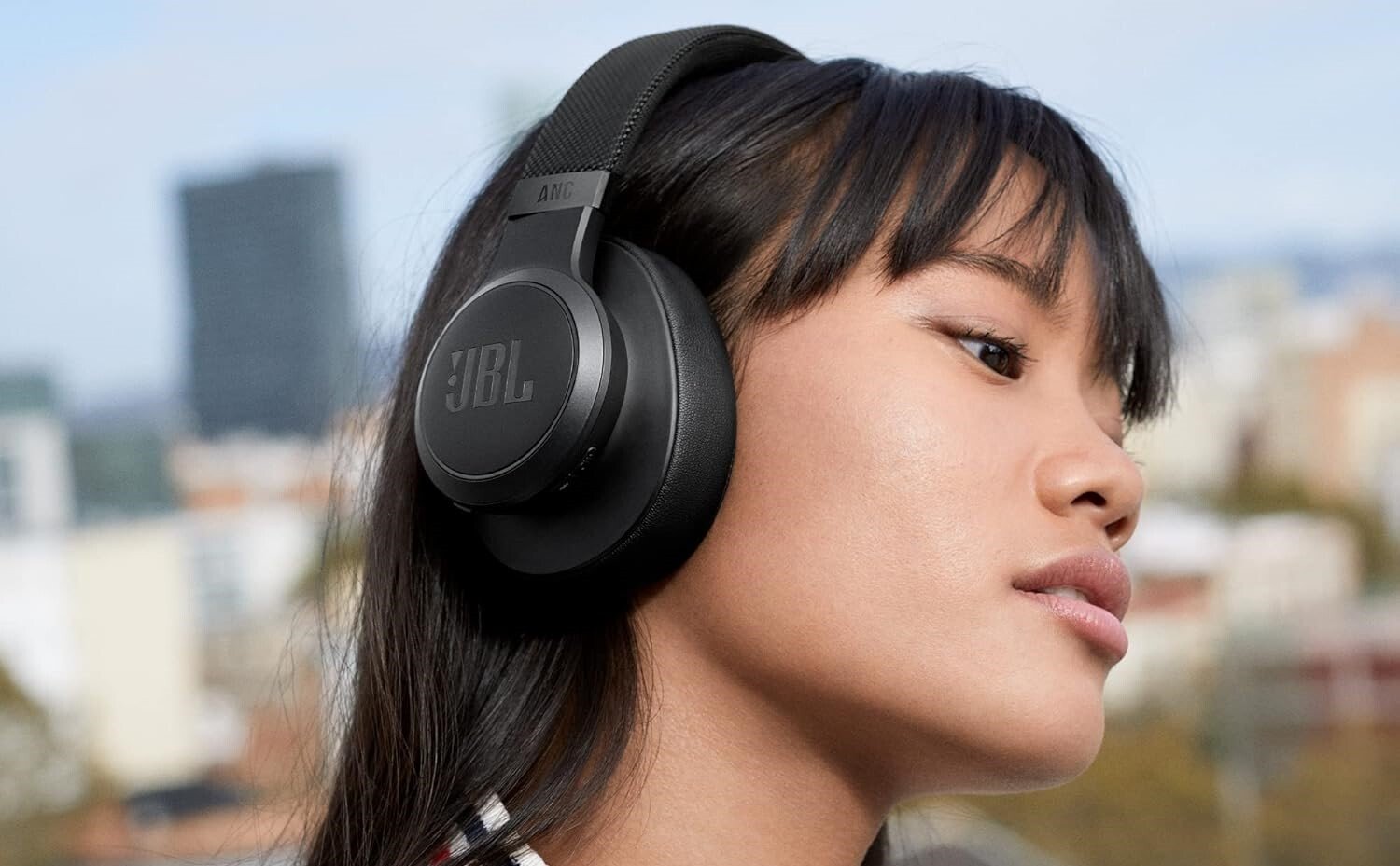 a person wears the JBL Live 660NC headphones outside in the sun