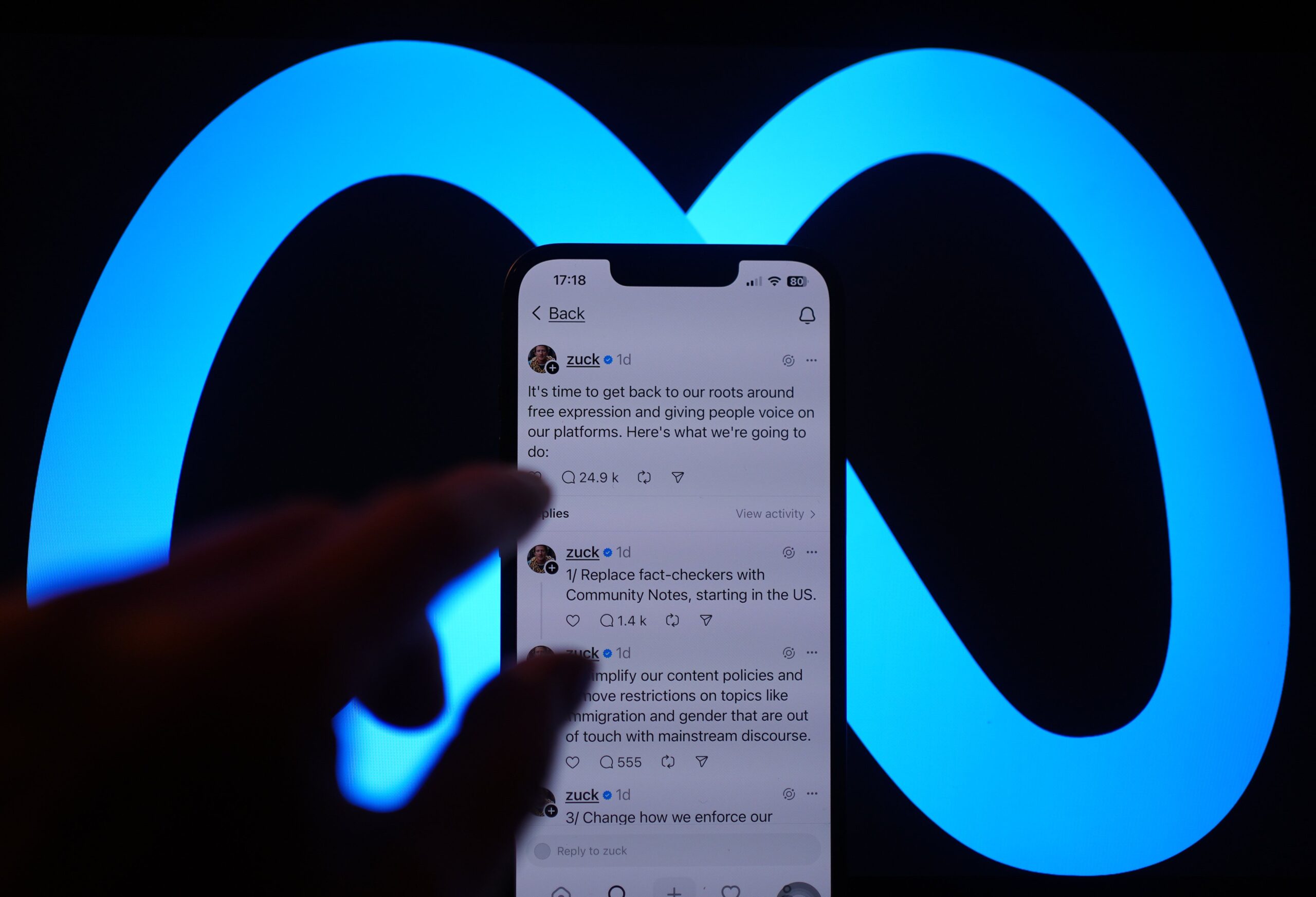 A person's hand tapping on Mark Zuckerberg's Threads post outlining his plan to remove fact checkers. 