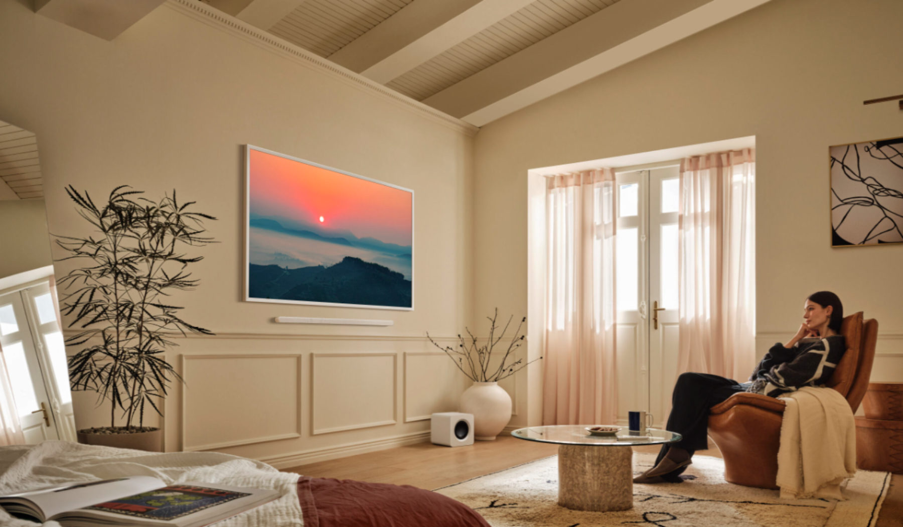 Person sitting in living room looking at Samsung's The Frame TV on wall