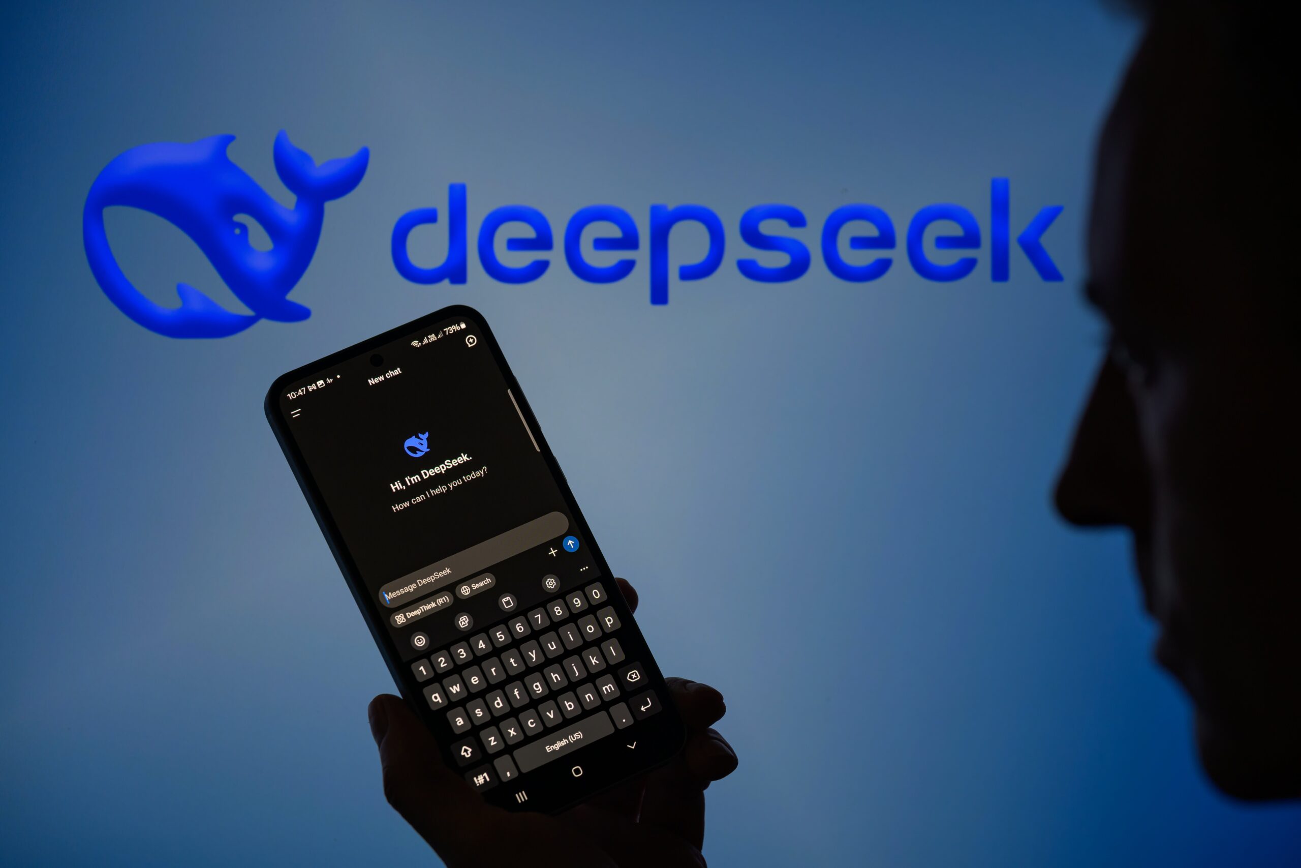 A person holds up a phone with the DeepSeek chatbot app open.