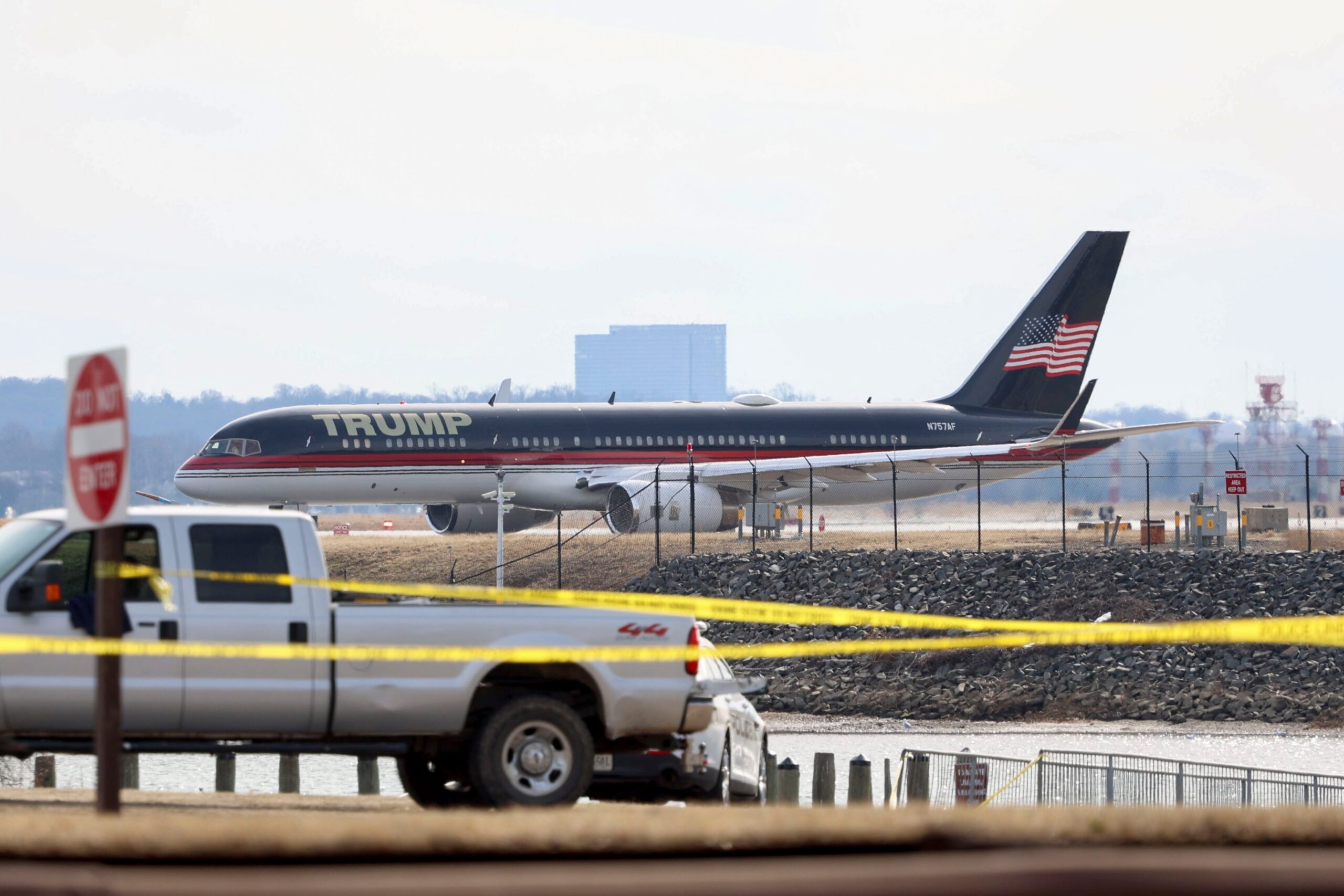 Trump's personal plane parked on the tarmac at Reagan National airport. Caution tape is strung across a street in front of it.