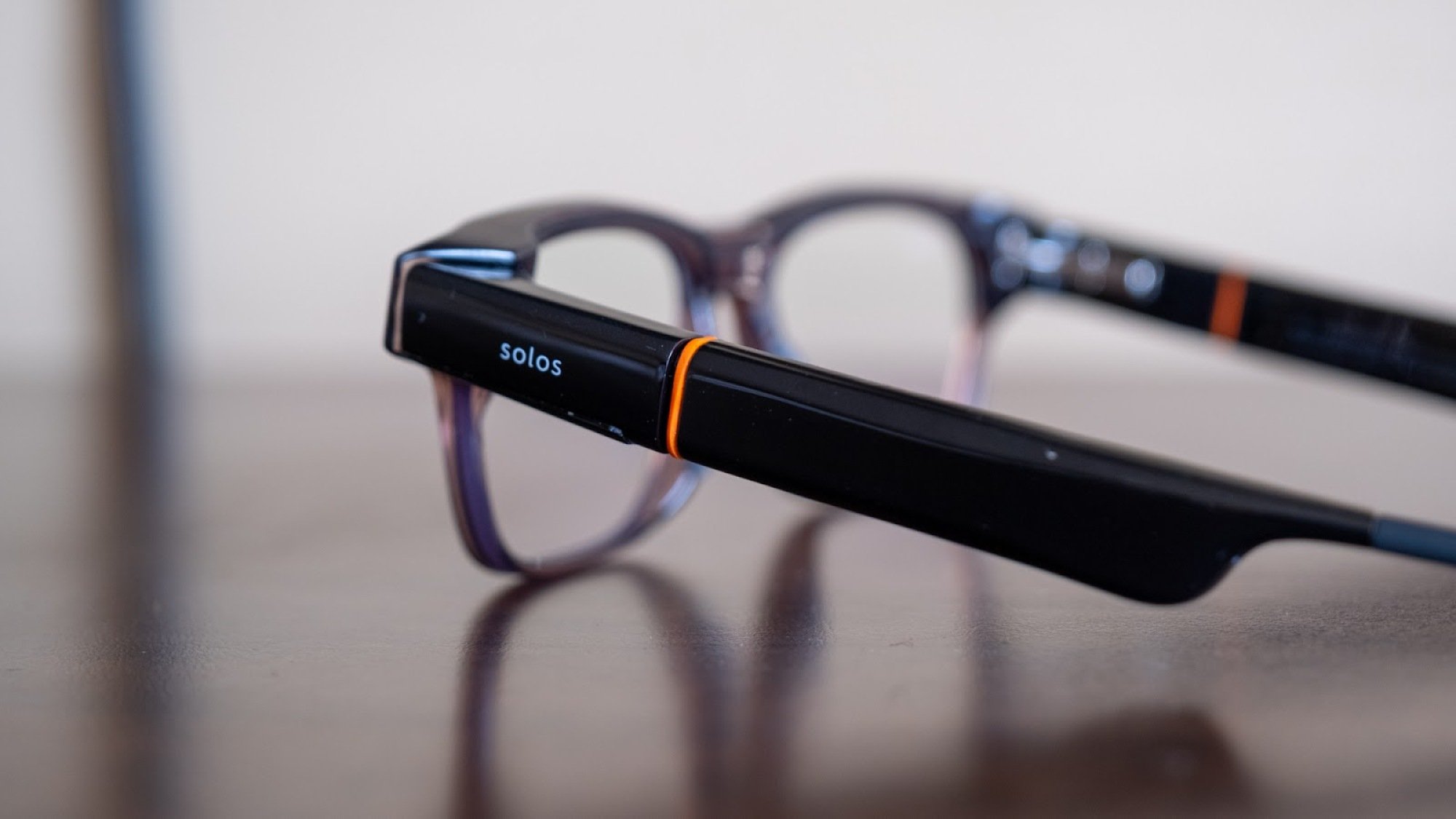 The Solos AirGo Vision smart glasses on a table.