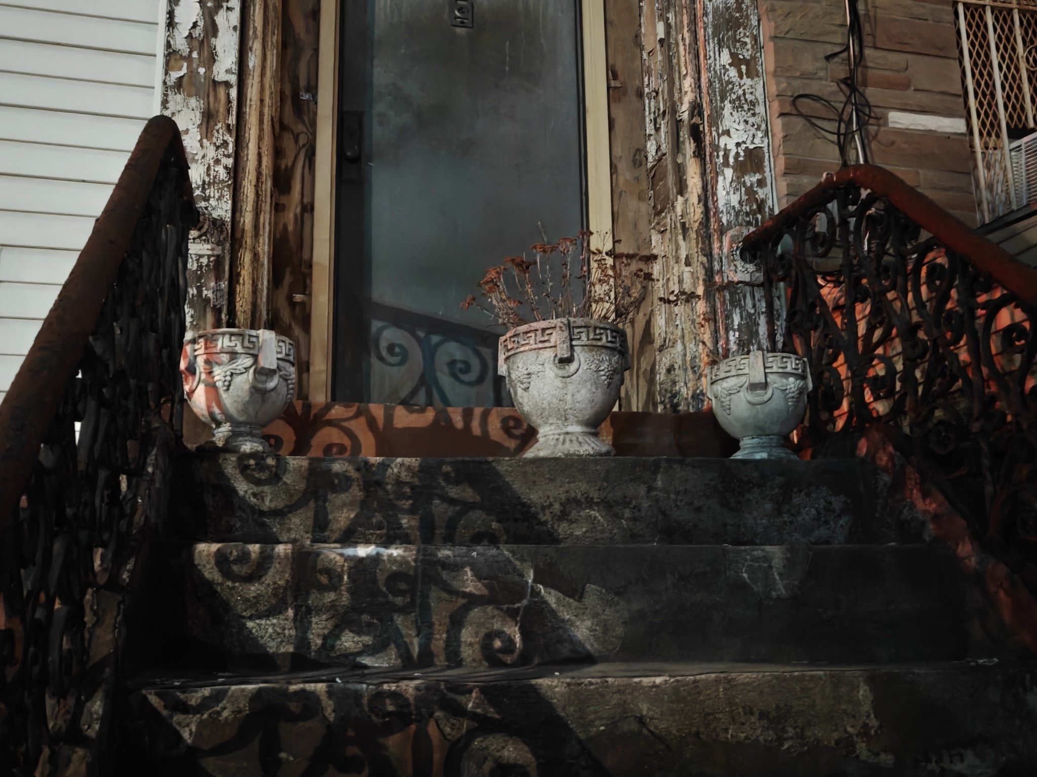 Image of three pots on a stoop in NYC at night