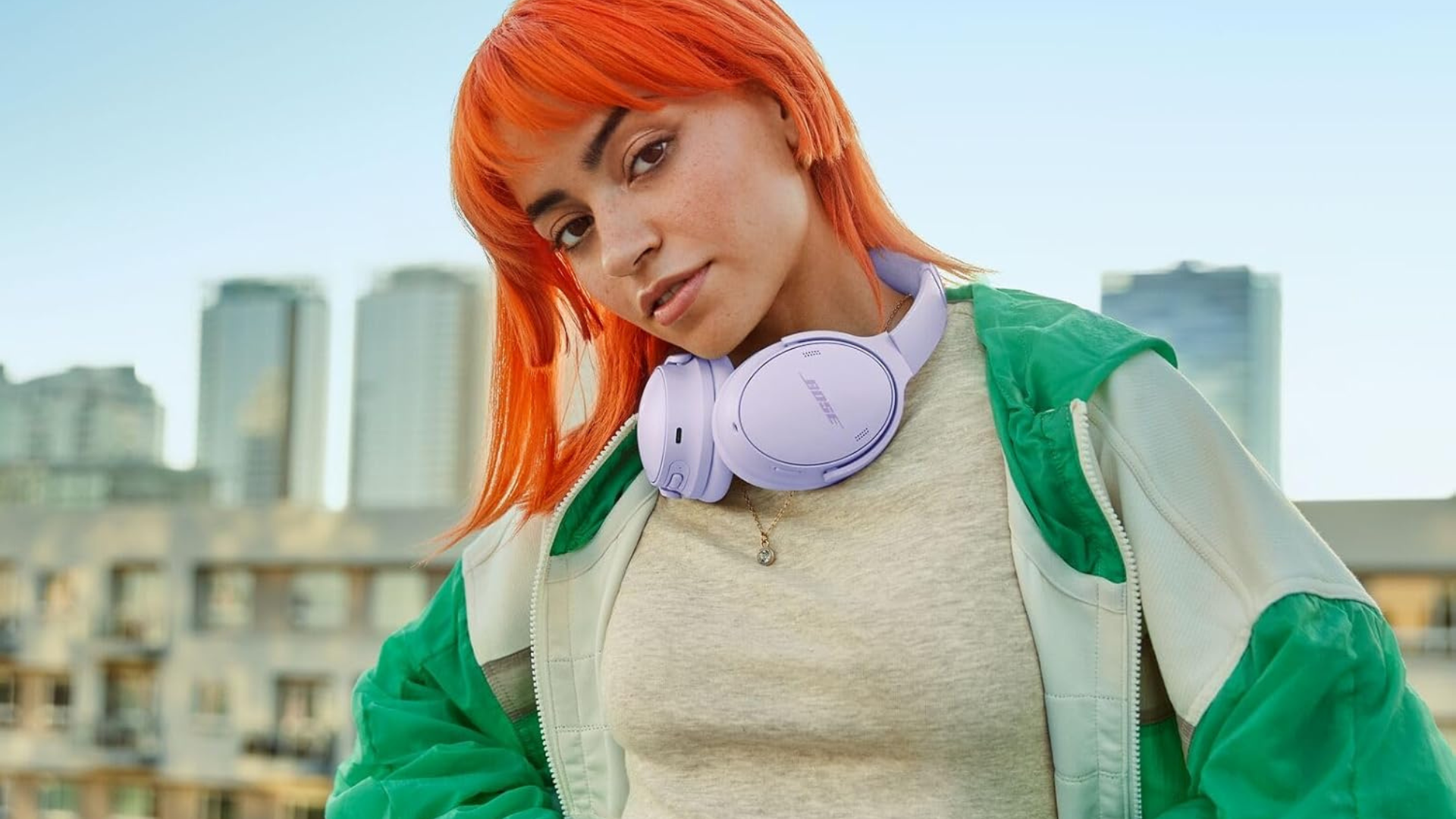 A person wearing Bose headphones on a rooftop