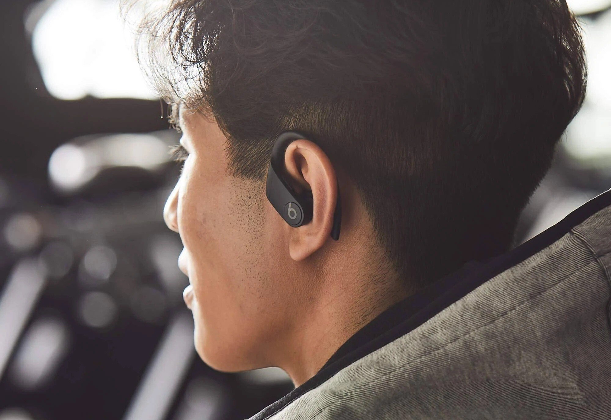 a profile of a person shows their left ear wearing the powerbeats pro earbuds