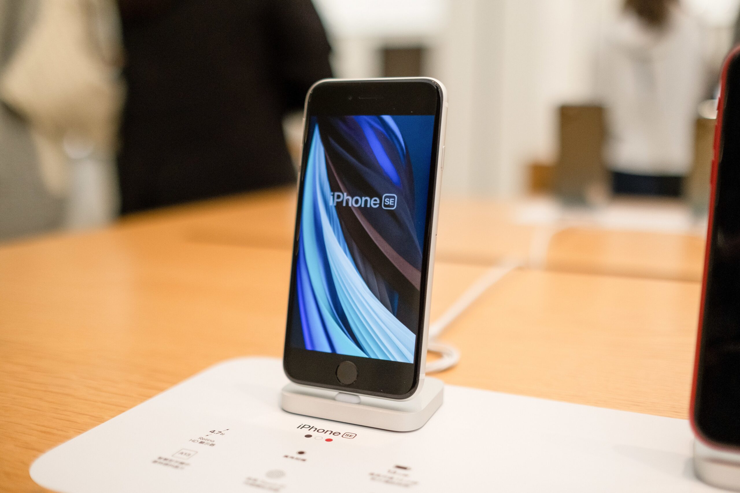 iphone se on a stand on a wooden table