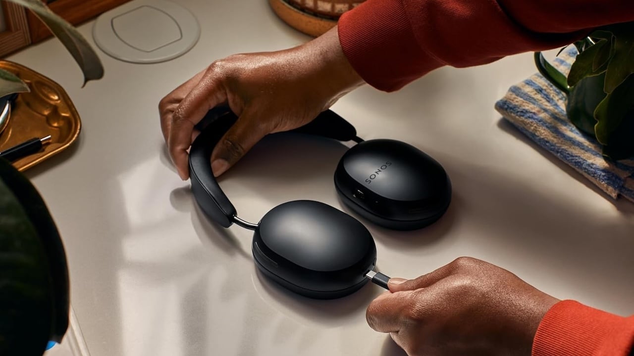 Person plugging Sonos Ace headphones into a charging cable