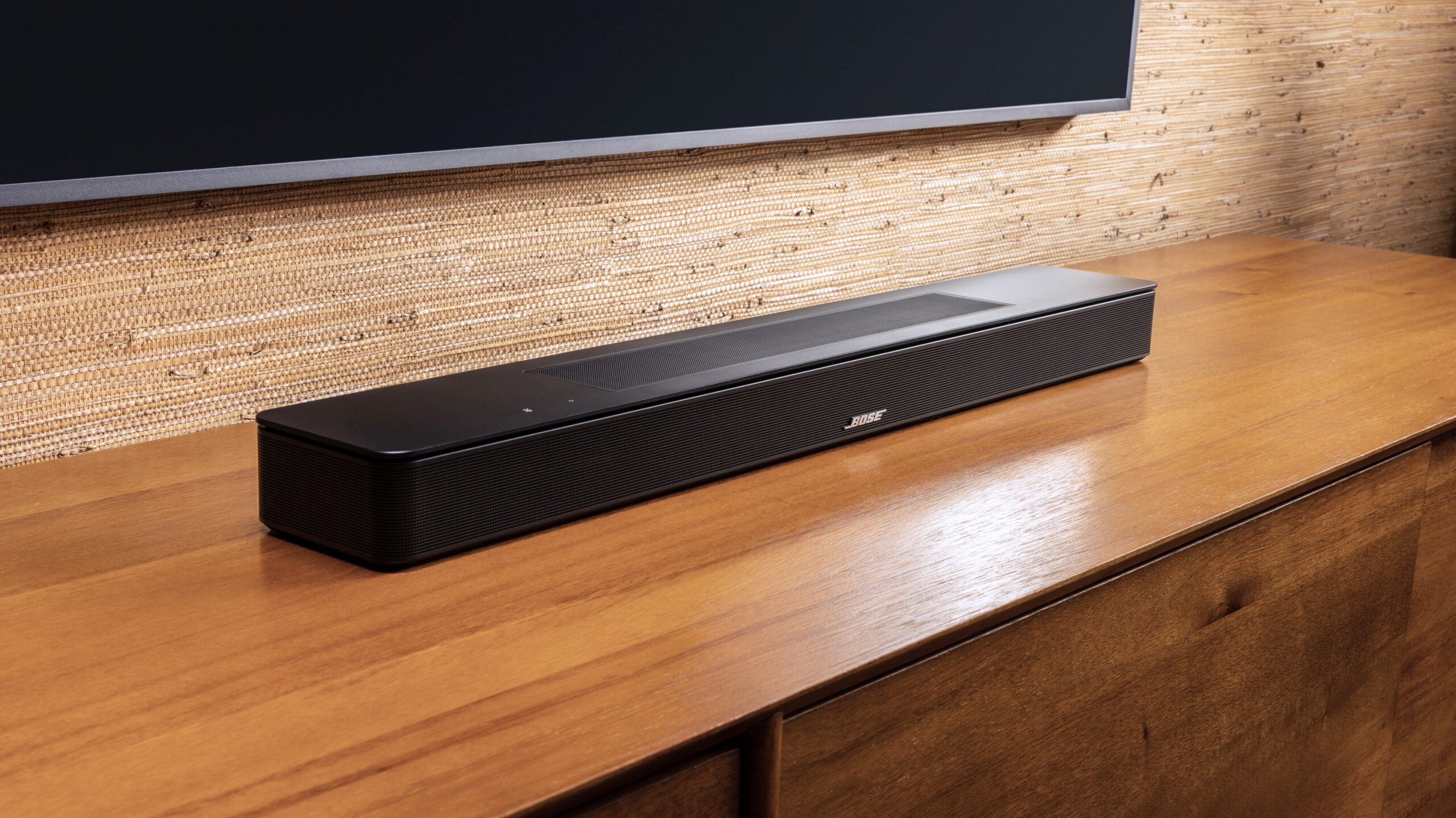 bose smart soundbar on media stand below tv