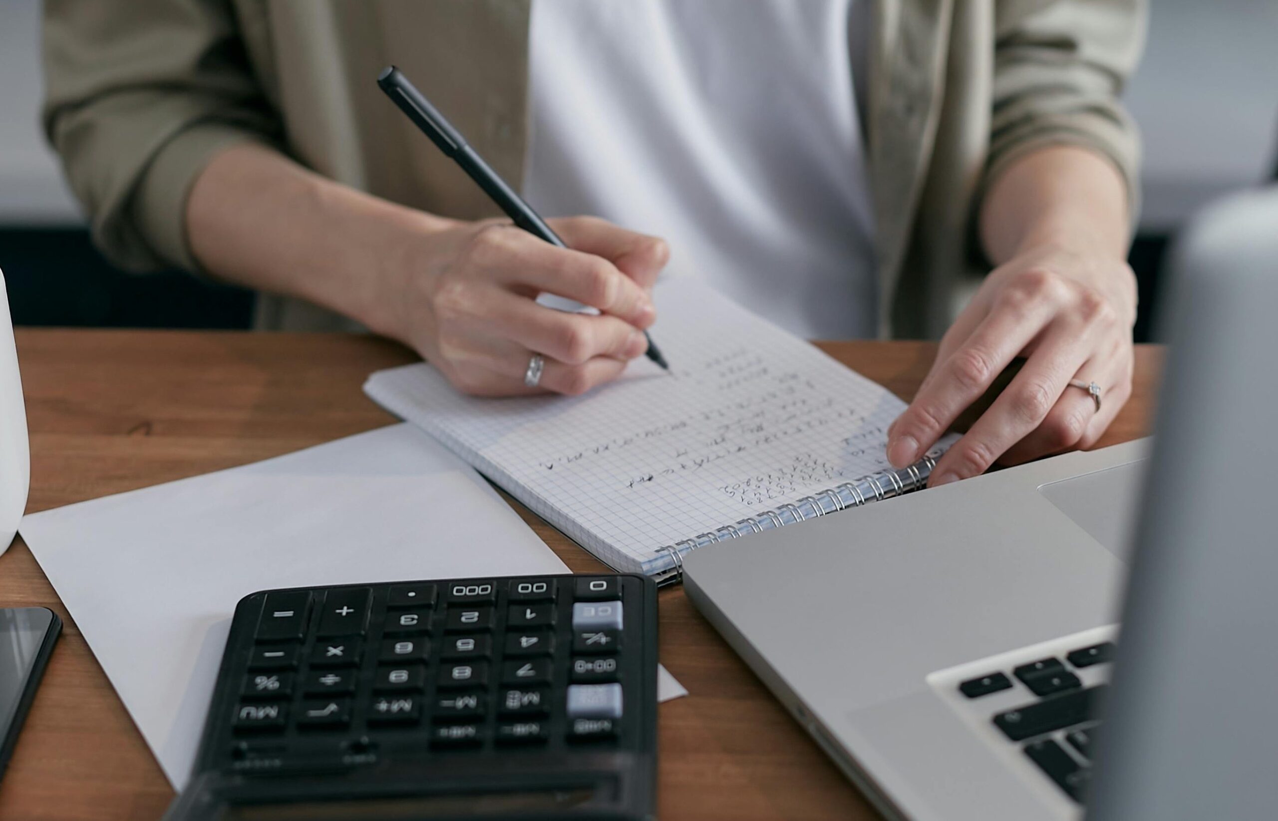 hand with paper, calculator and laptop