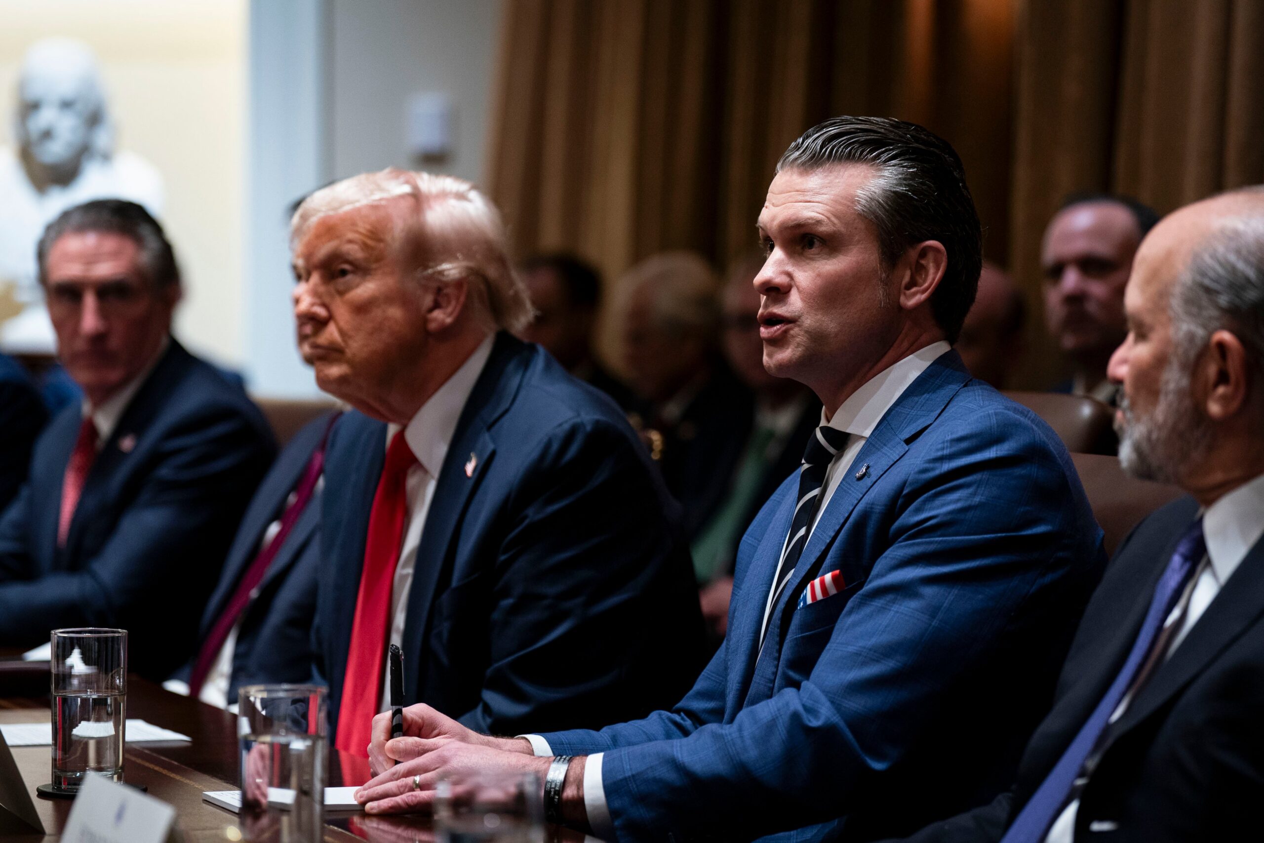 President Donald Trump and Defense Secretary Pete Hegseth sit at a table during a cabinet meeting.