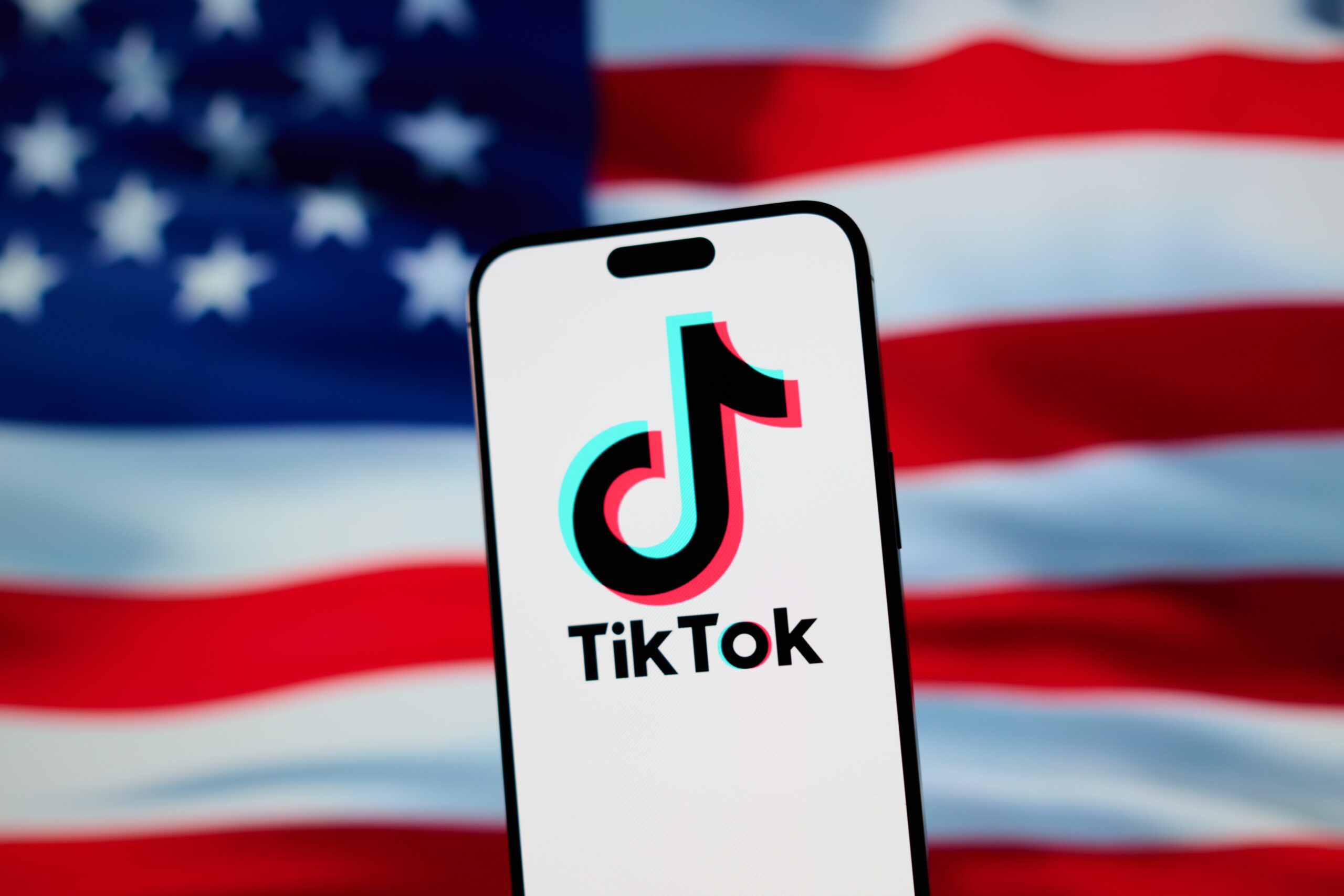 the tiktok logo on a phone in front of the american flag