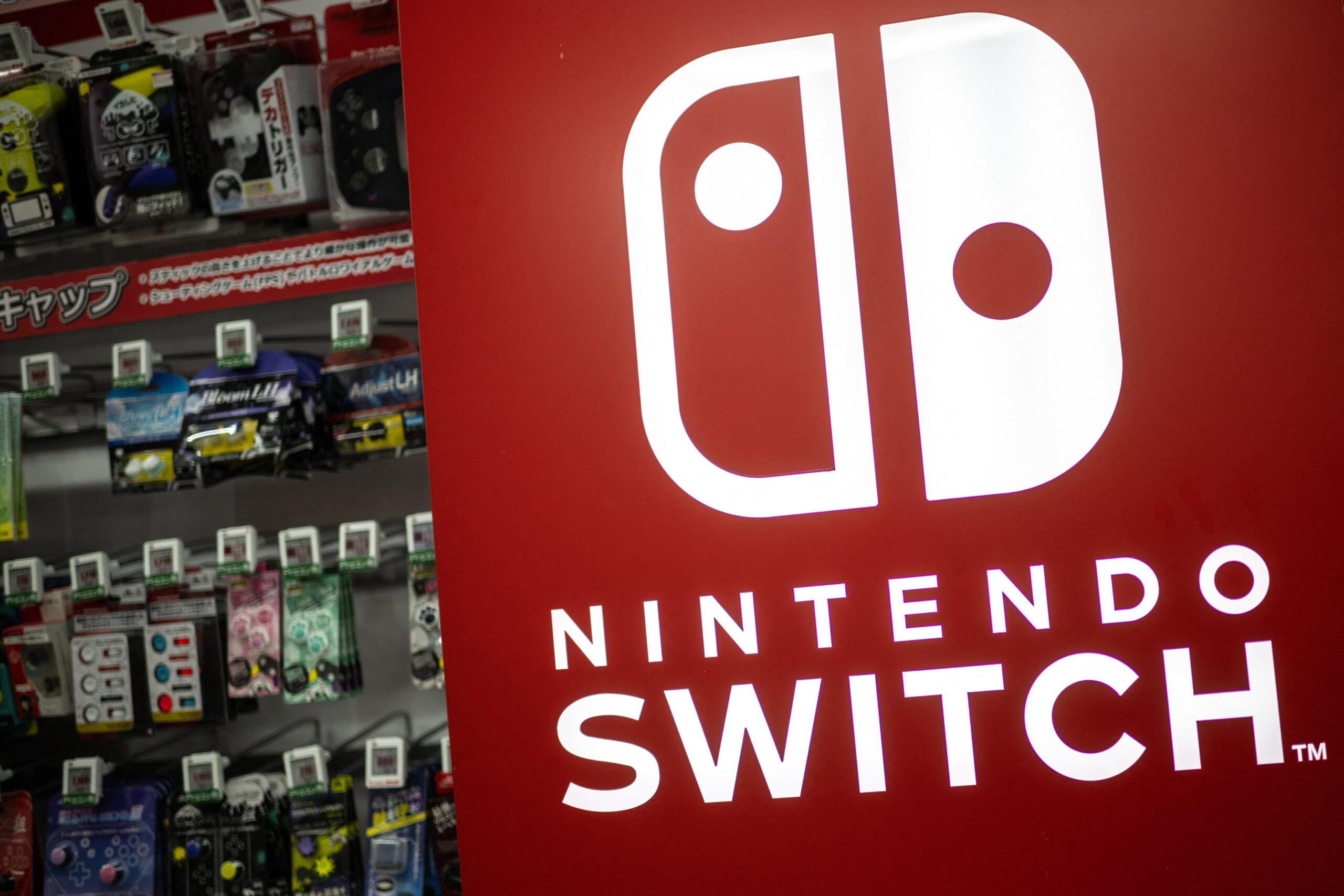 A red Nintendo Switch sign in front of a display of Switch games.