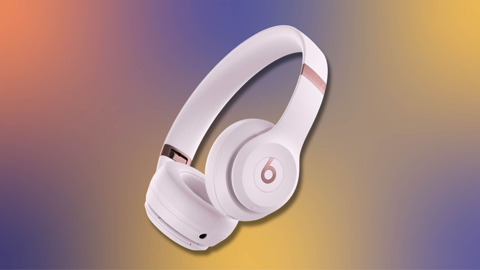 pink beats solo 4 headphones against a purple, yellow, and orange gradient background