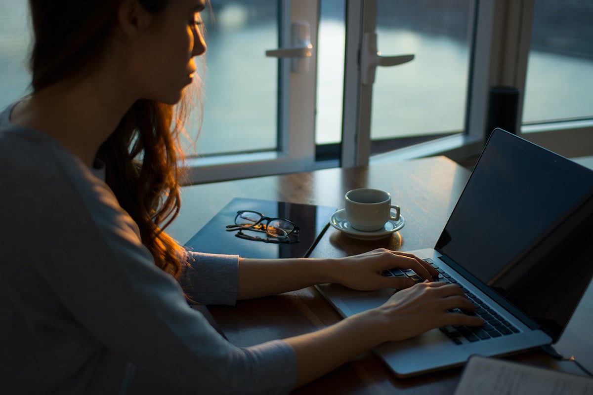 woman using laptop in dark room