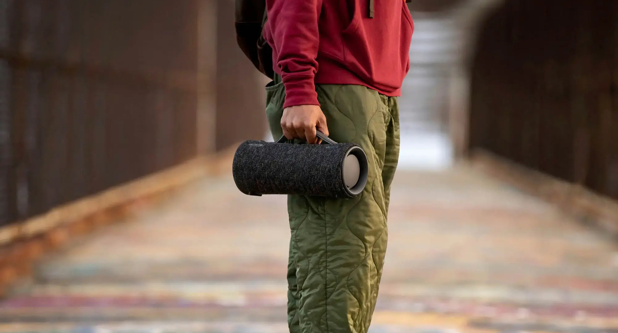 Person standing in the street and holding the Sony XG300 portable Bluetooth speaker. 