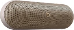 a champagne gold beats pill speaker against a white background