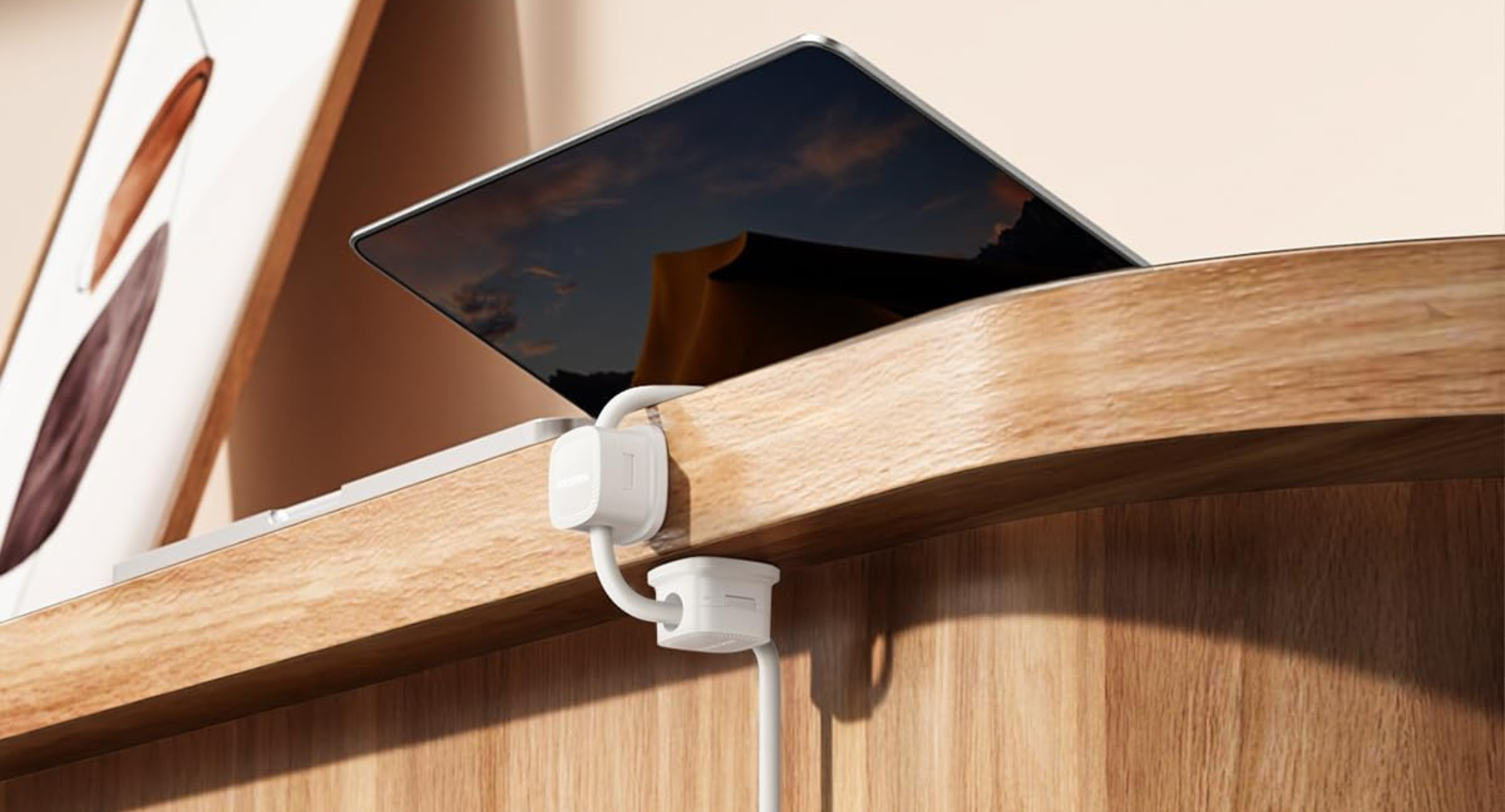 Two white Rocoren magnetic cable clips attached to the edge of a wooden desk