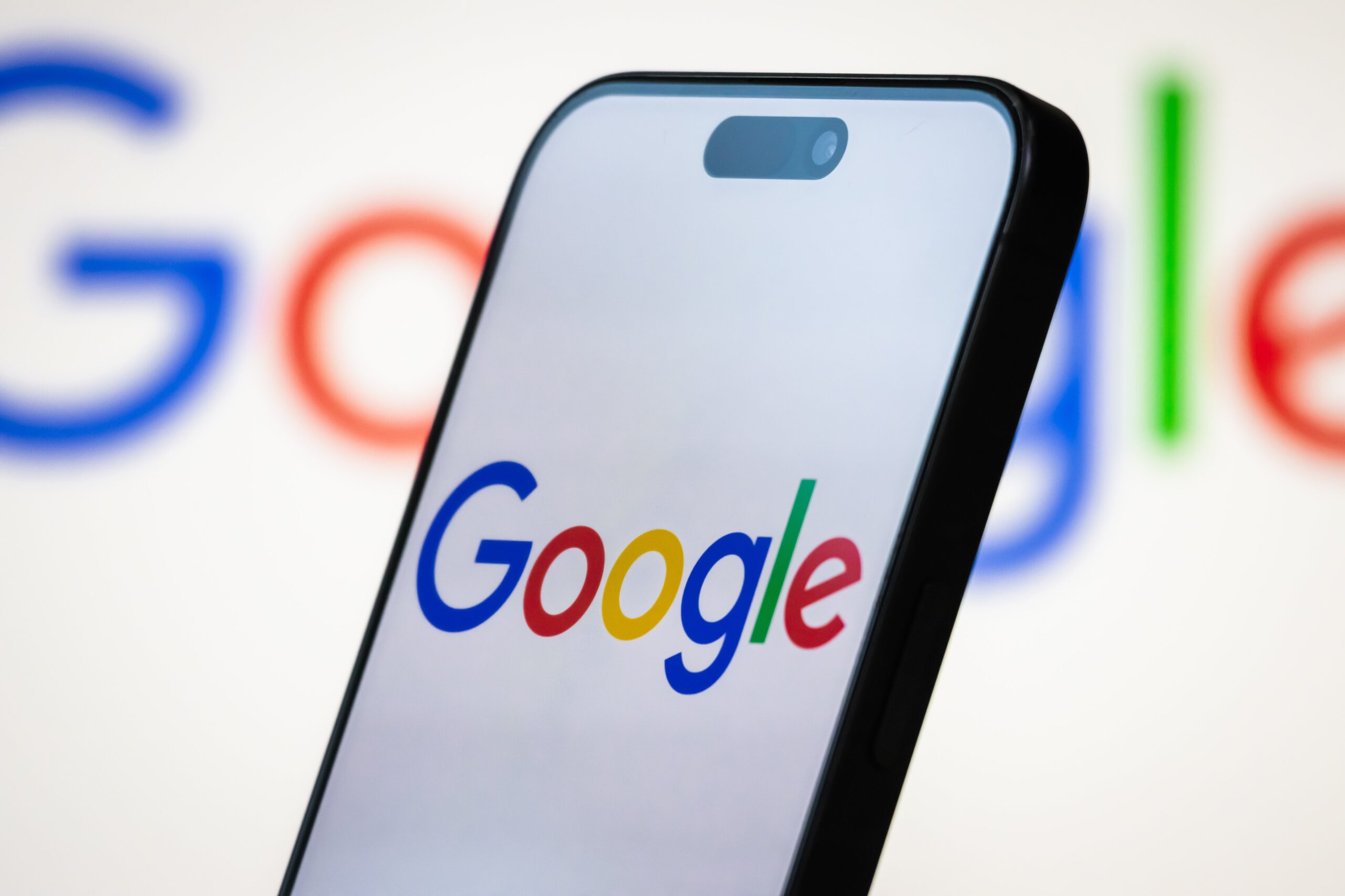 google logo on a phone screen with google logo in background