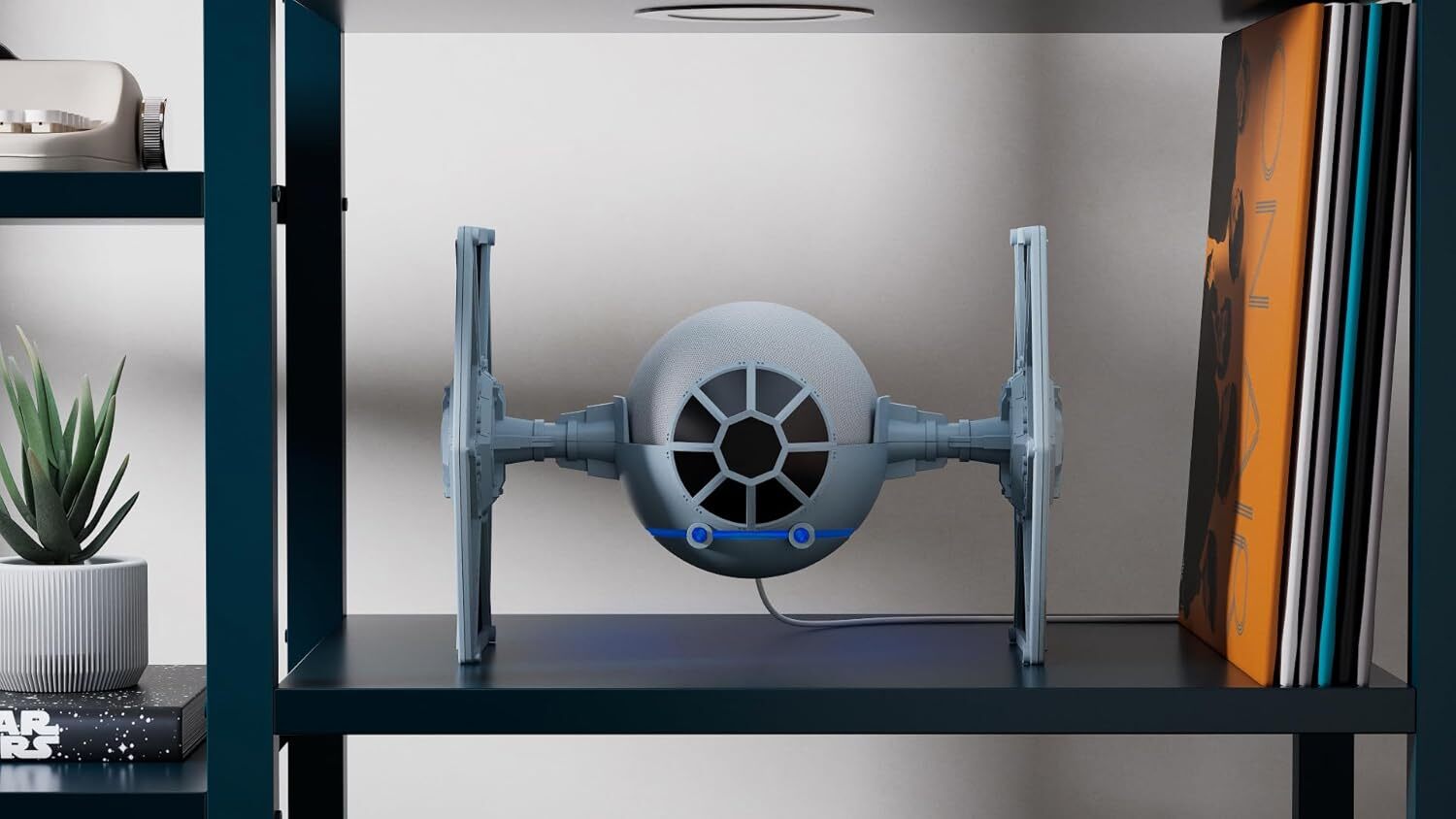 the star wars TIE fighter stand holds the Amazon Echo dot while sitting on a book shelf