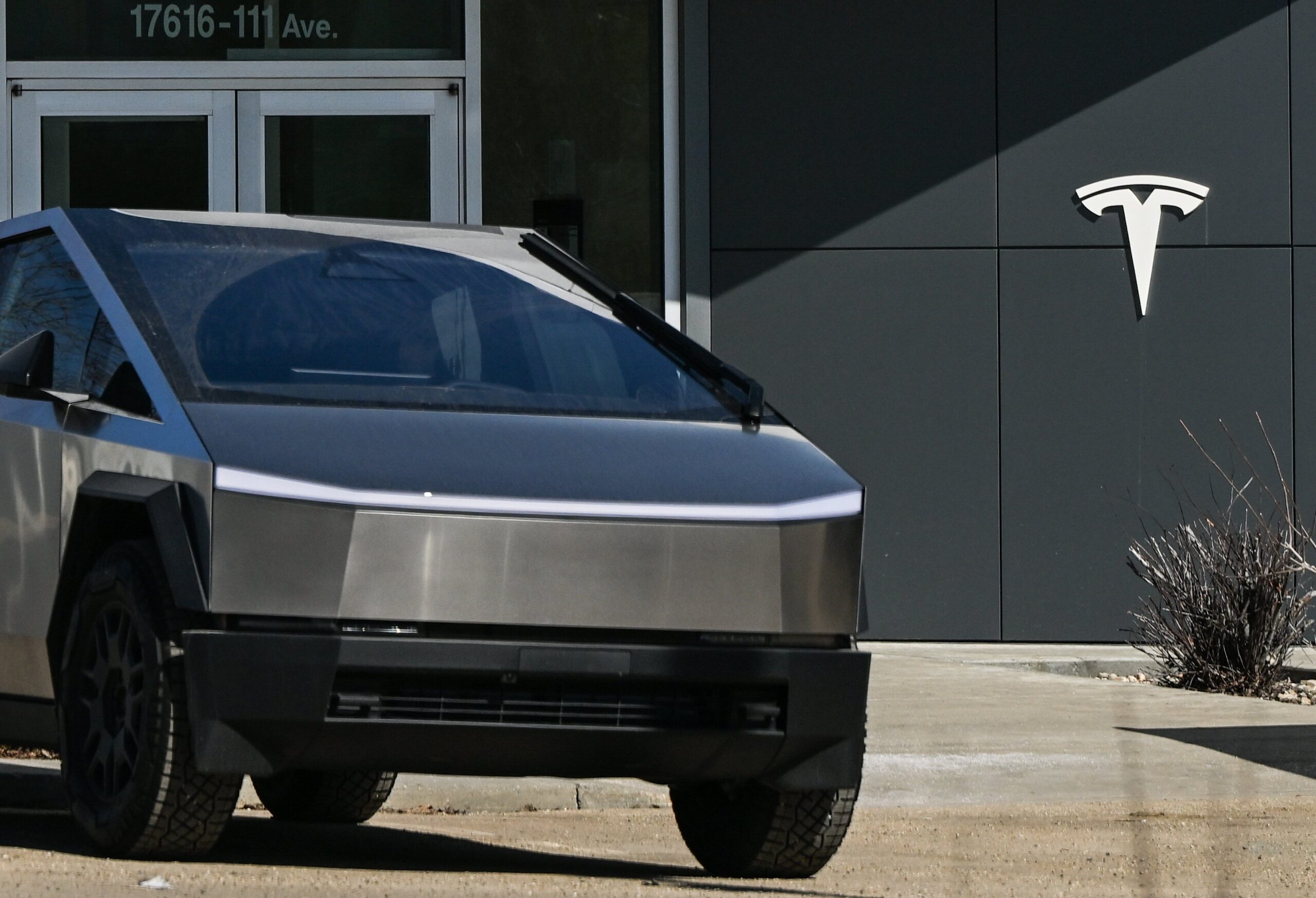 Cybertruck in front of Tesla logo