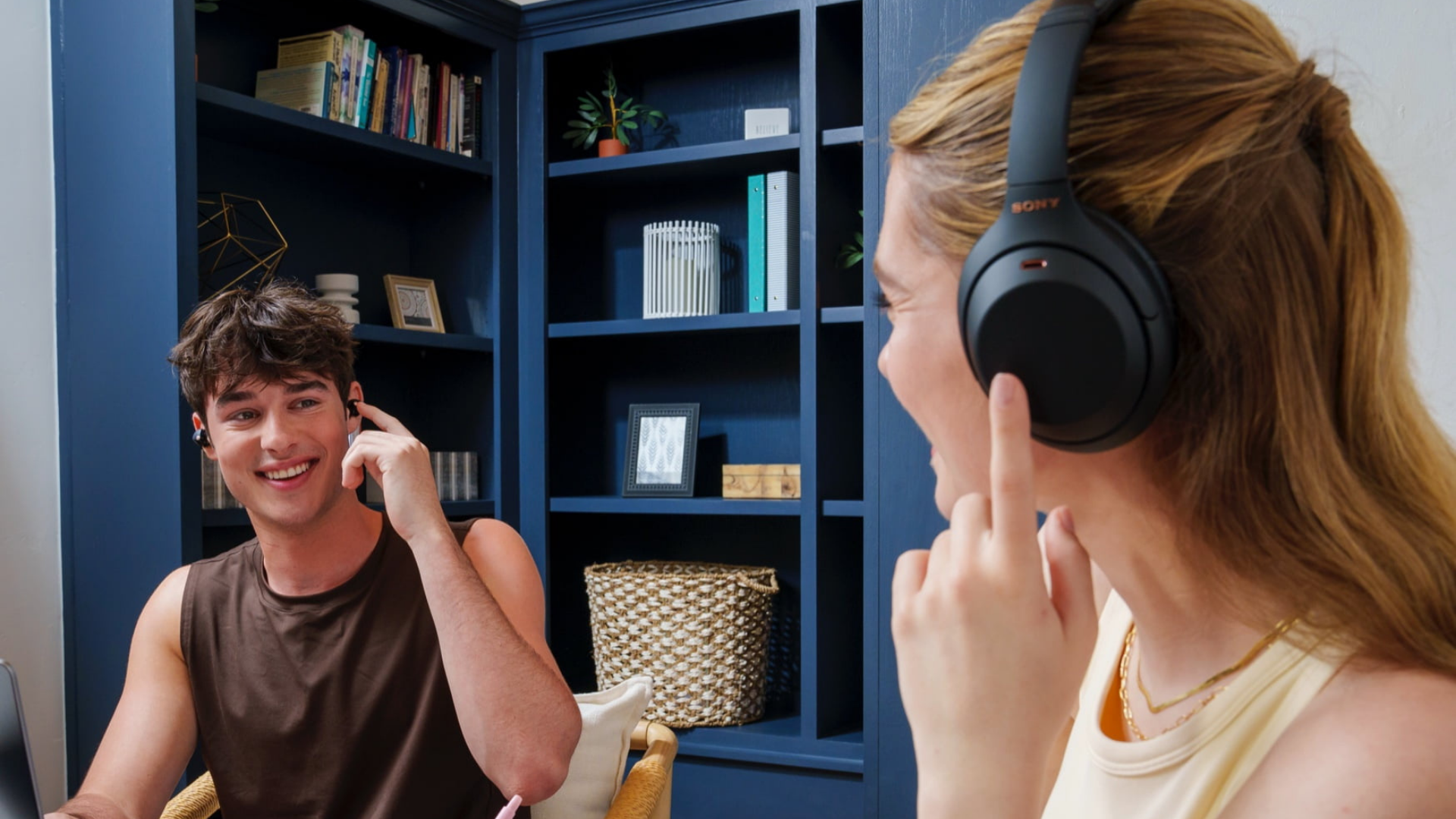 woman wearing Sony Wh-1000Xm4 headphones while talking to man