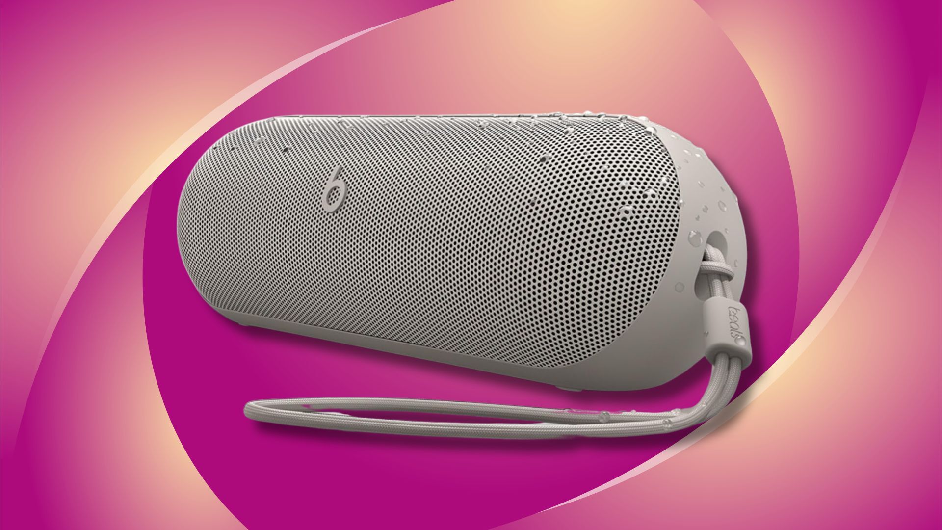 beats pill portable speaker against a dark pink and yellow patterned background