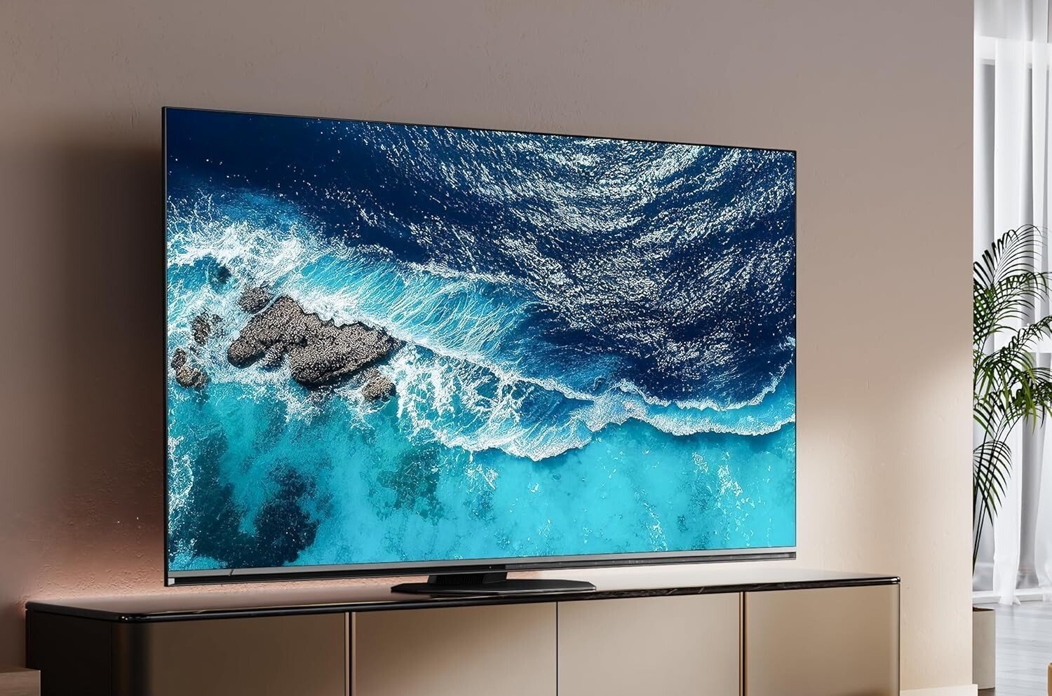 the Hisense U8N TV sits on an entertainment center in a living room while displaying ocean waves