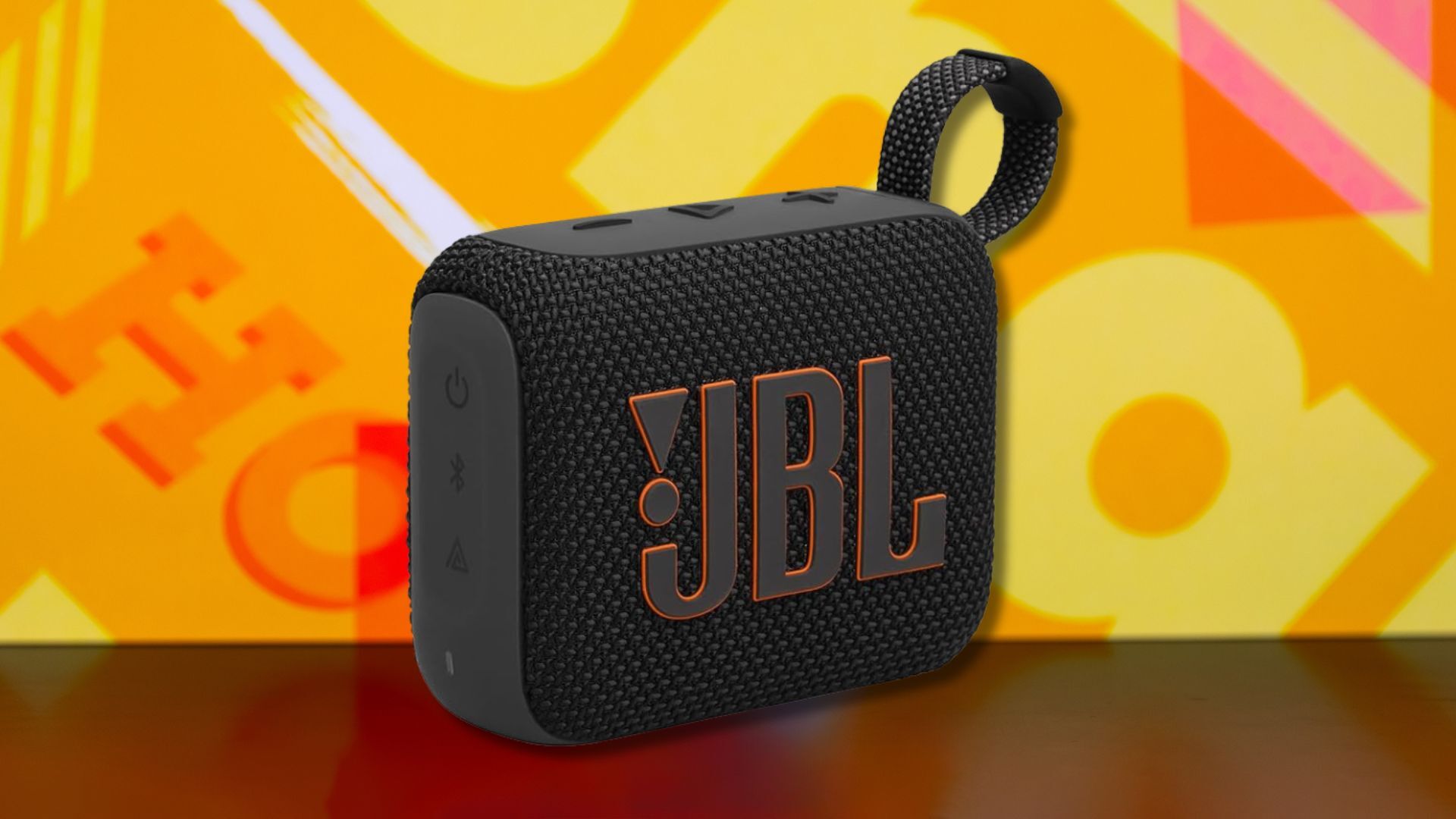 jbl go 4 portable speaker against a yellow patterned background