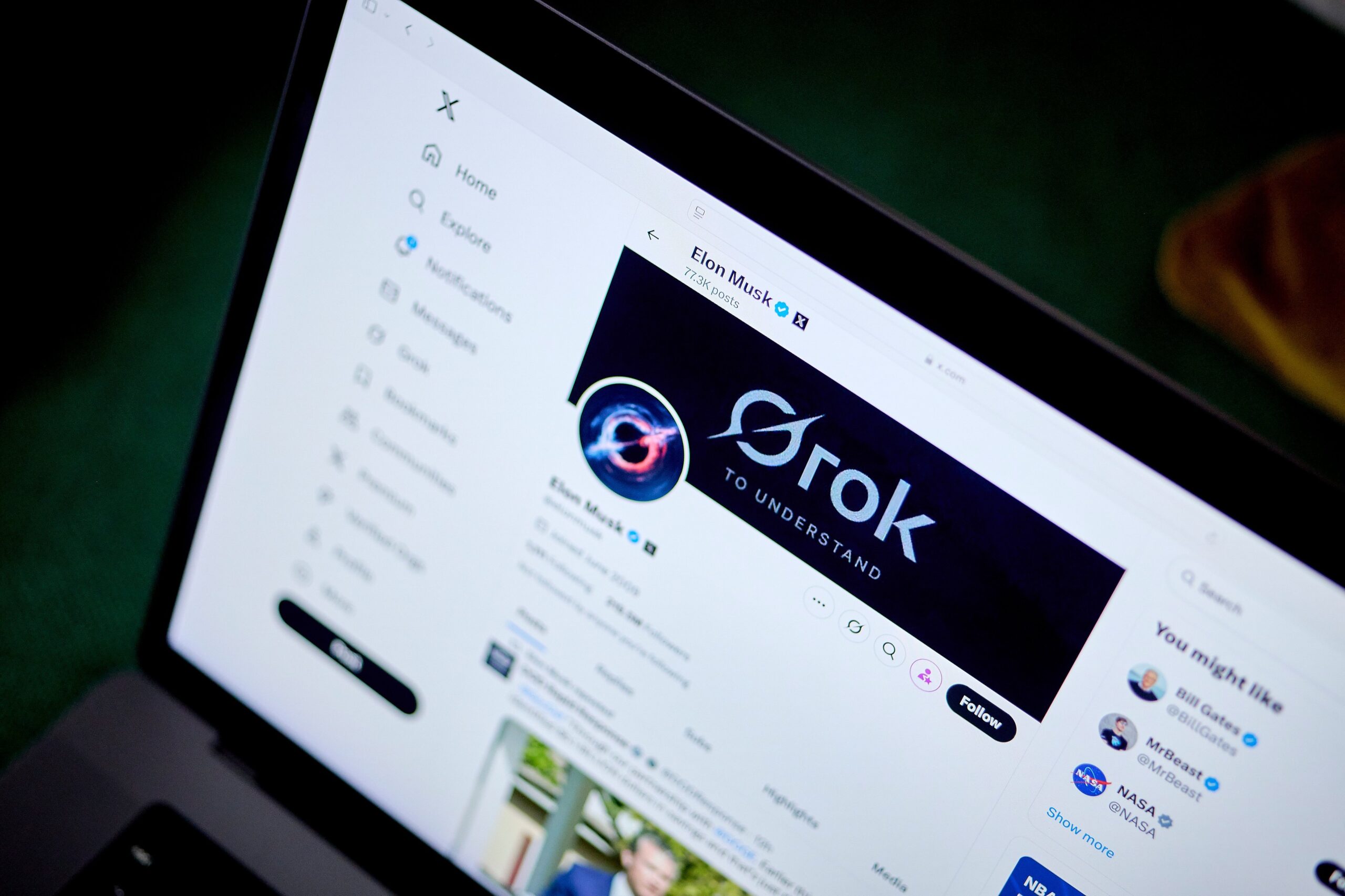 laptop screen showing elon musk's x profil with grok banner image