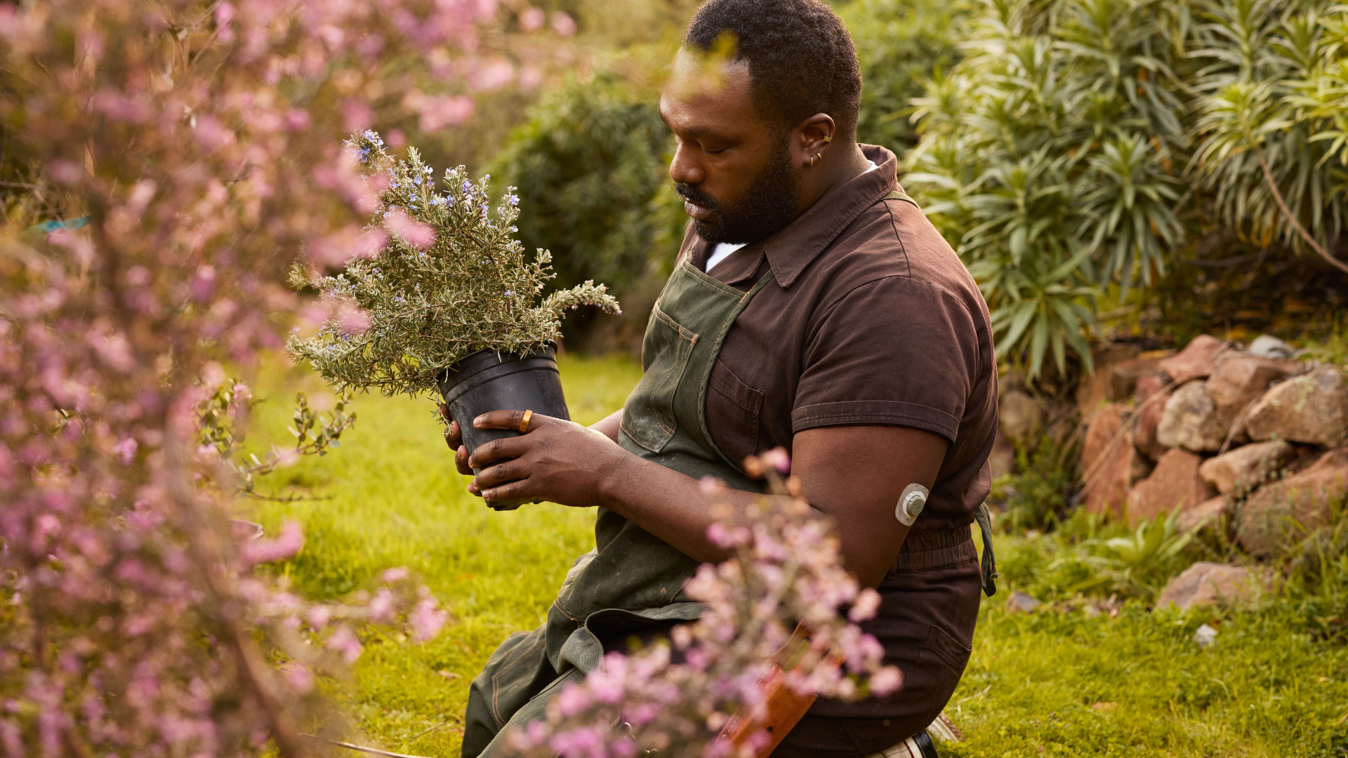 A person wearing an Oura Ring and Stelo Glucose Sensor while gardening