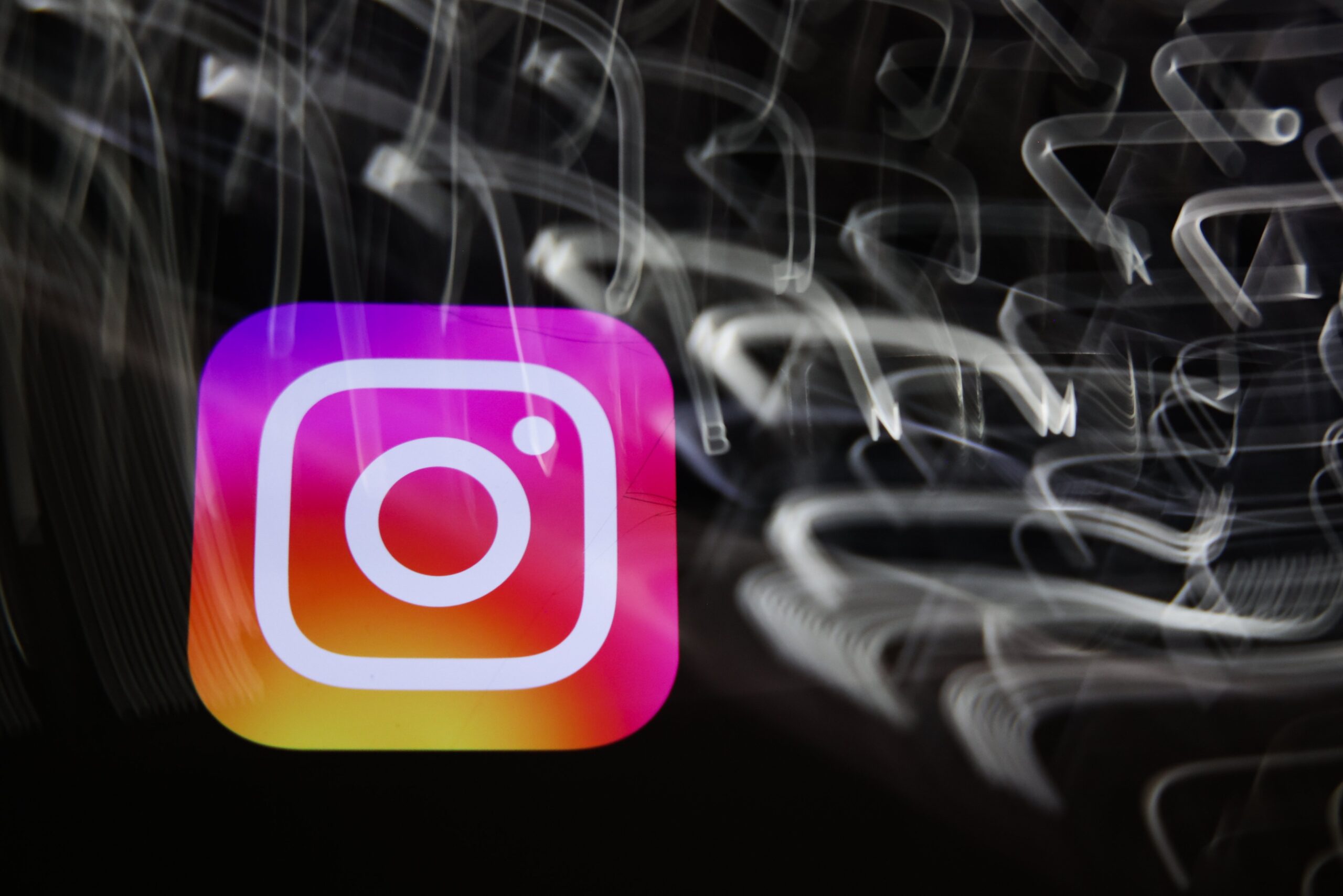 The Instagram logo amid a swirl of blurred white lights on a black background.