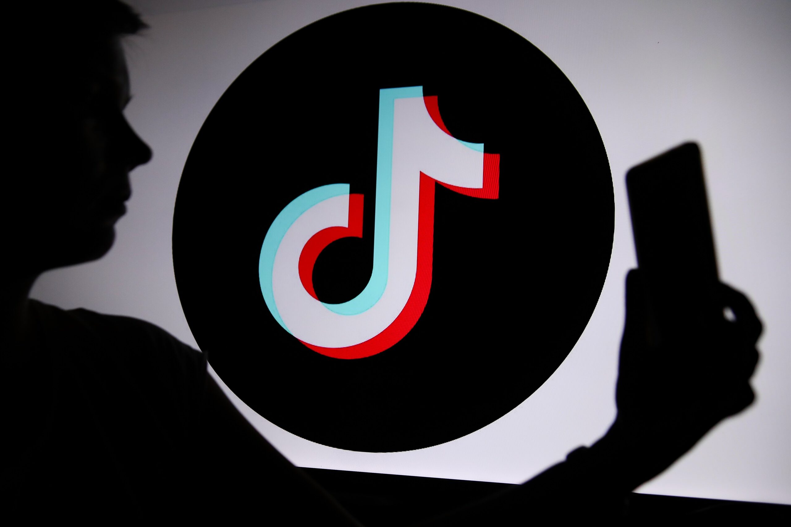The TikTok logo with a person holding a phone in their hand is seen in Knurow, Poland, on April 20, 2025.