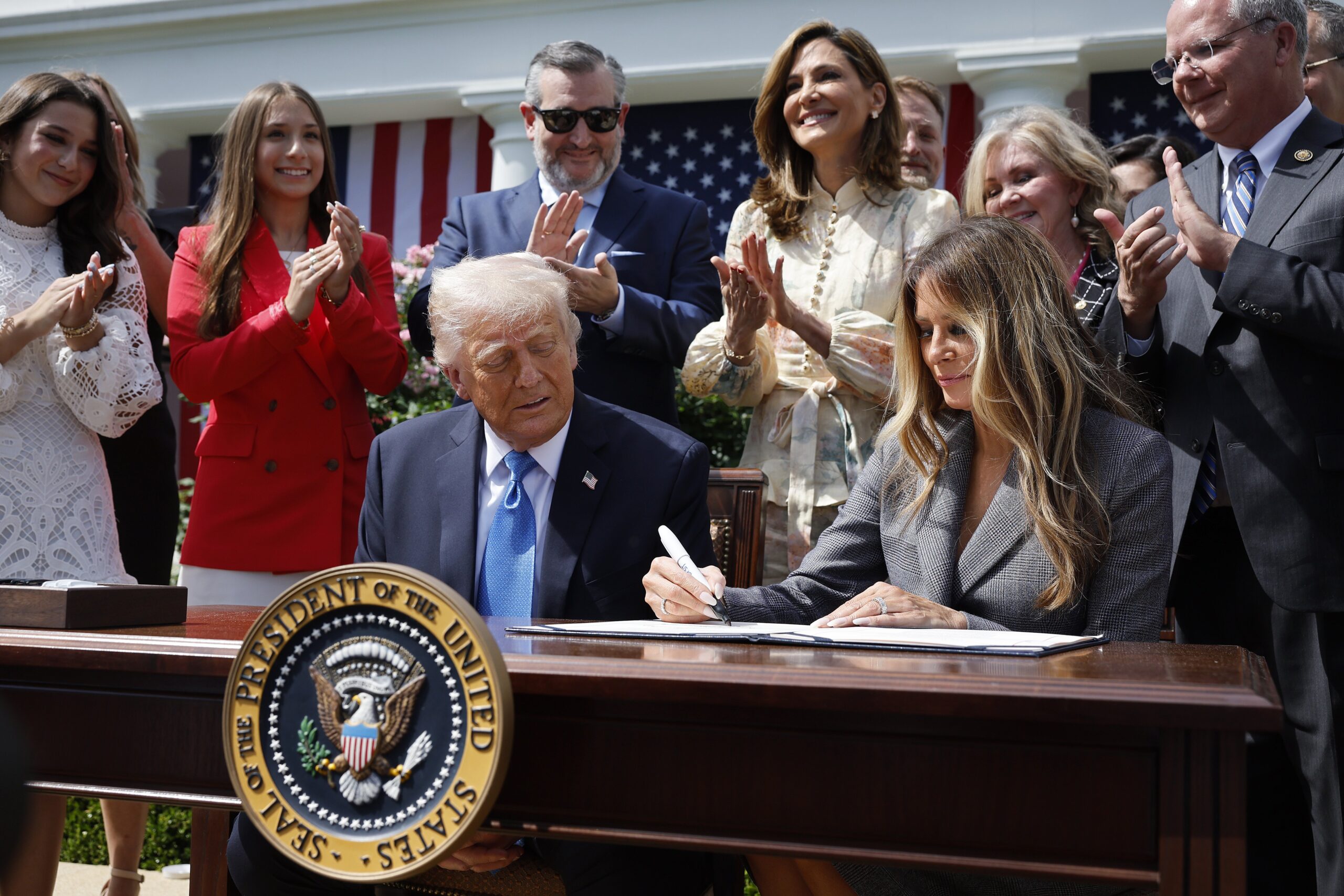 First lady Melania Trump signs the TAKE IT DOWN Act alongside President Donald Trump